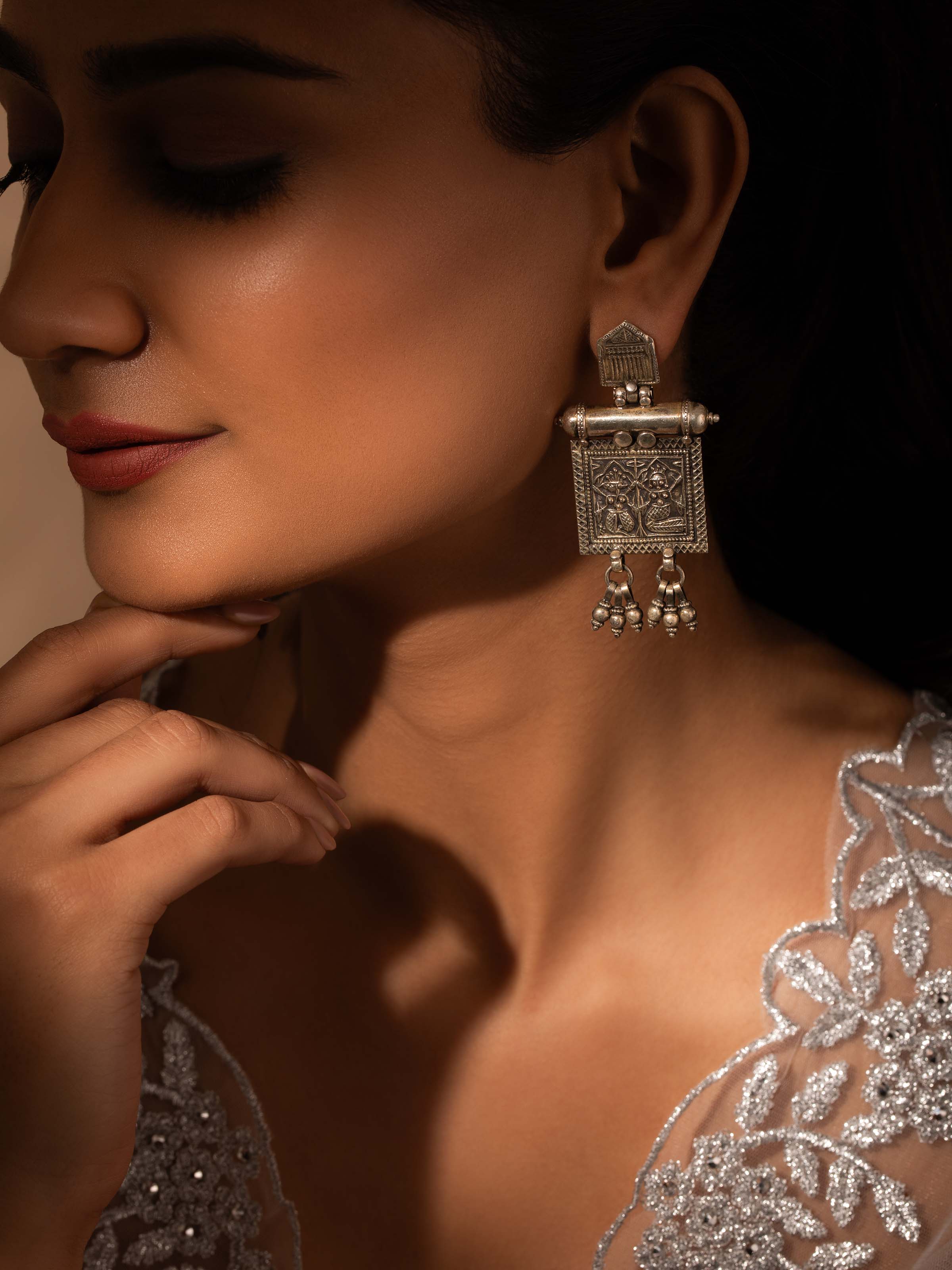 Close-up view of Smithing Drop Earrings highlighting intricate metal patterns and craftsmanship.