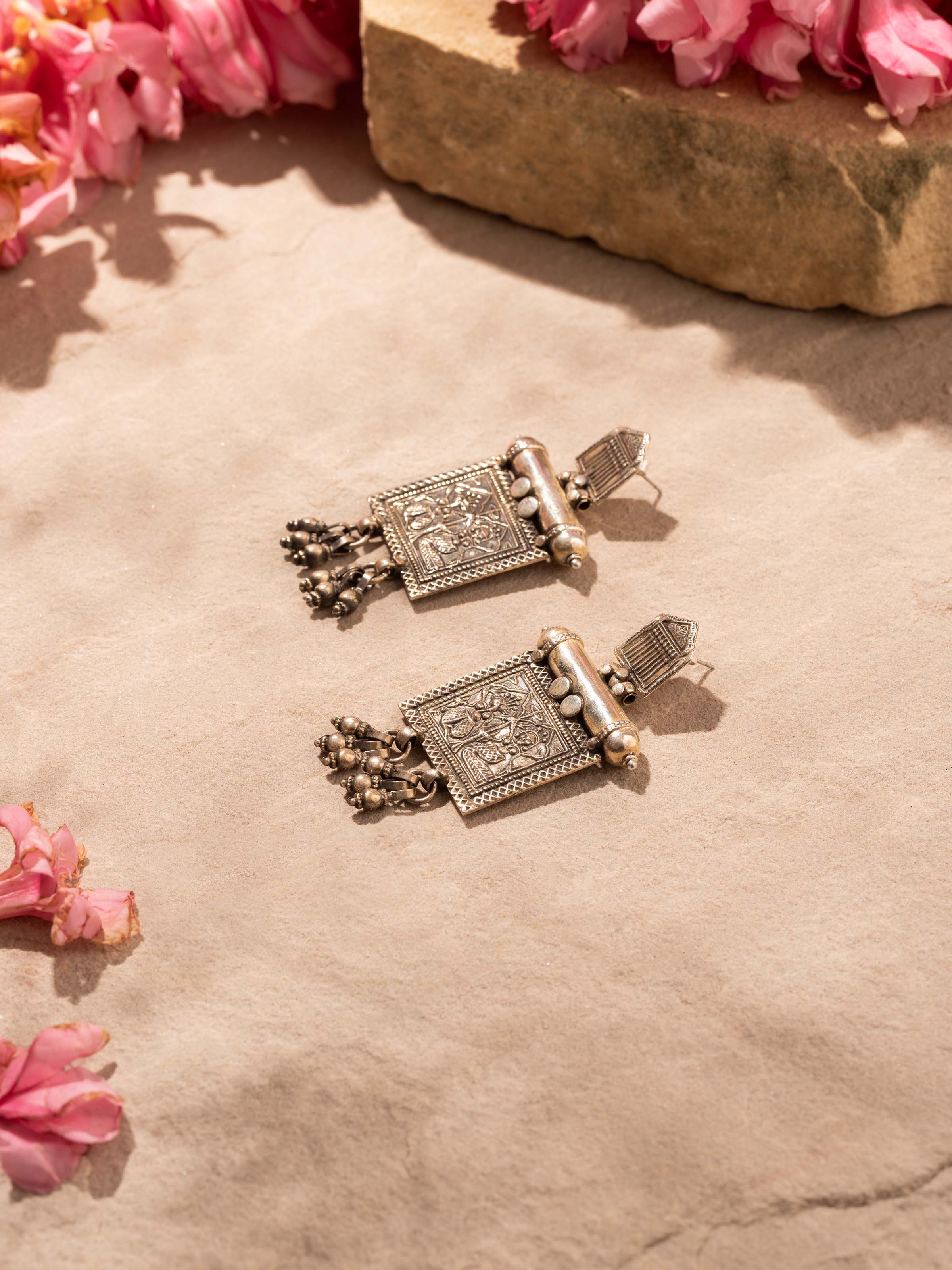 Overhead view of Smithing Drop Earrings showing the detailed drop design and elegant finish.