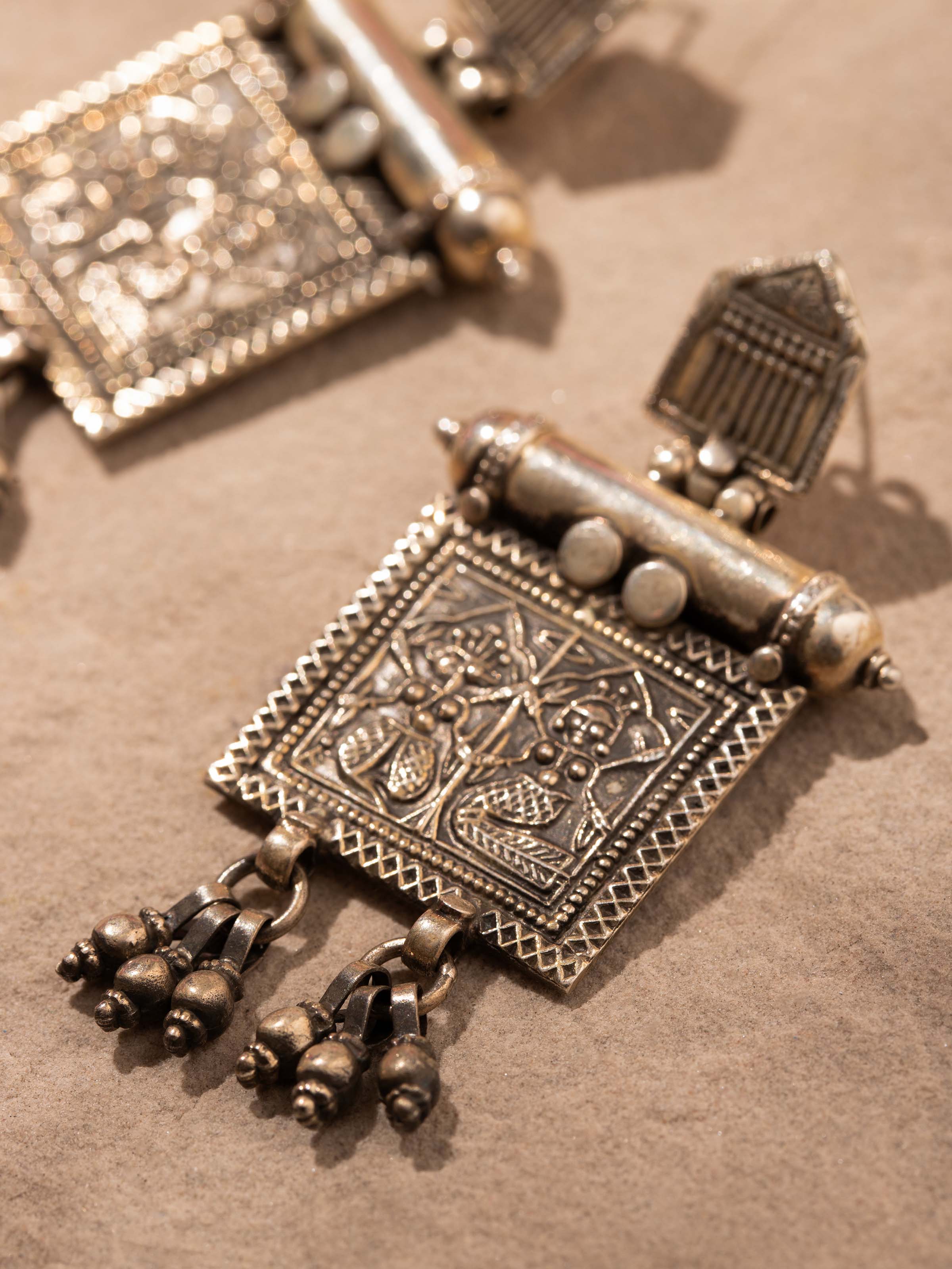 Back view of Smithing Drop Earrings featuring the secure fastening and smooth metal finish.