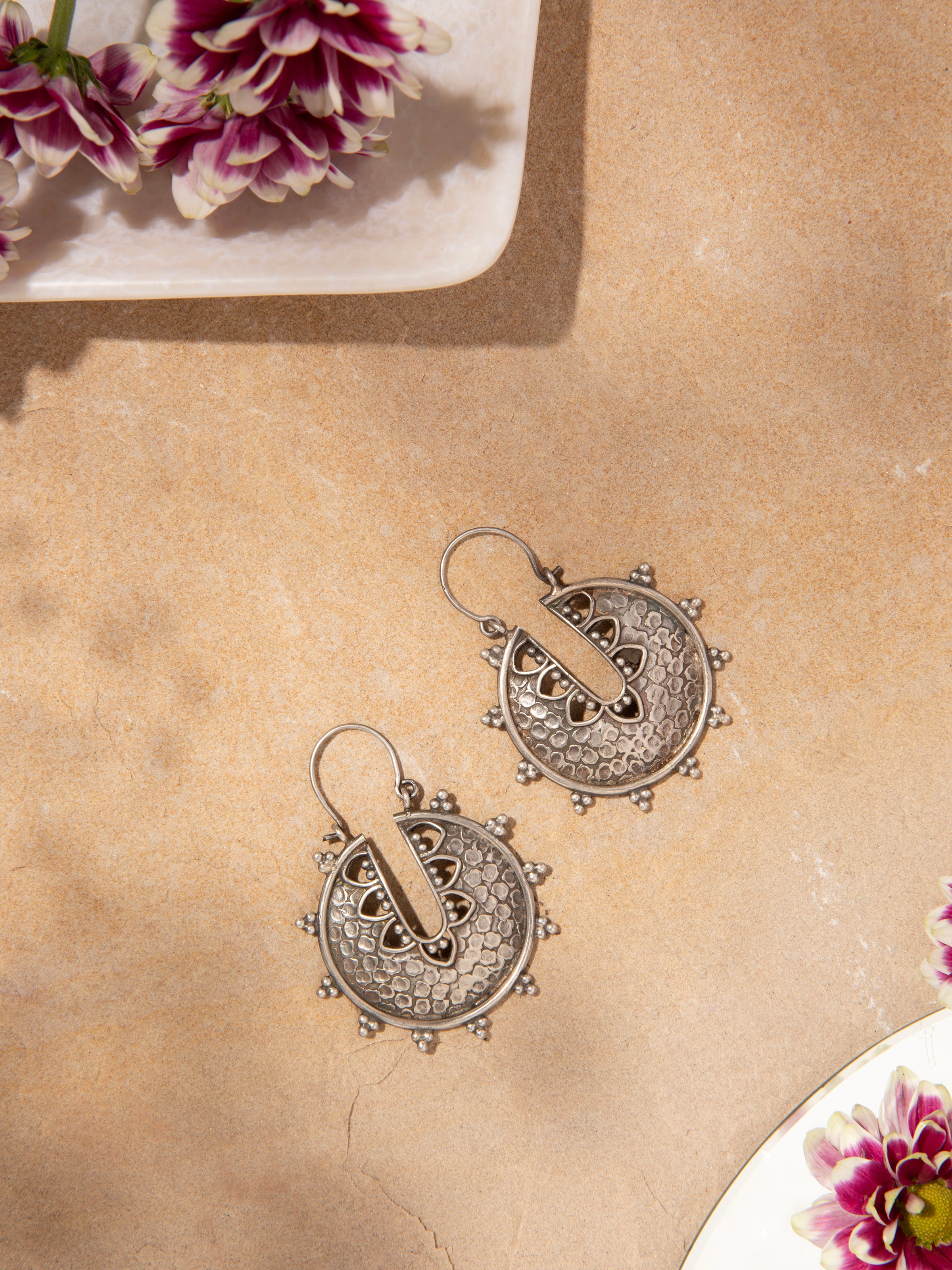 Close-up of Smithing Hoop Earrings showing intricate craftsmanship and polished metal finish.