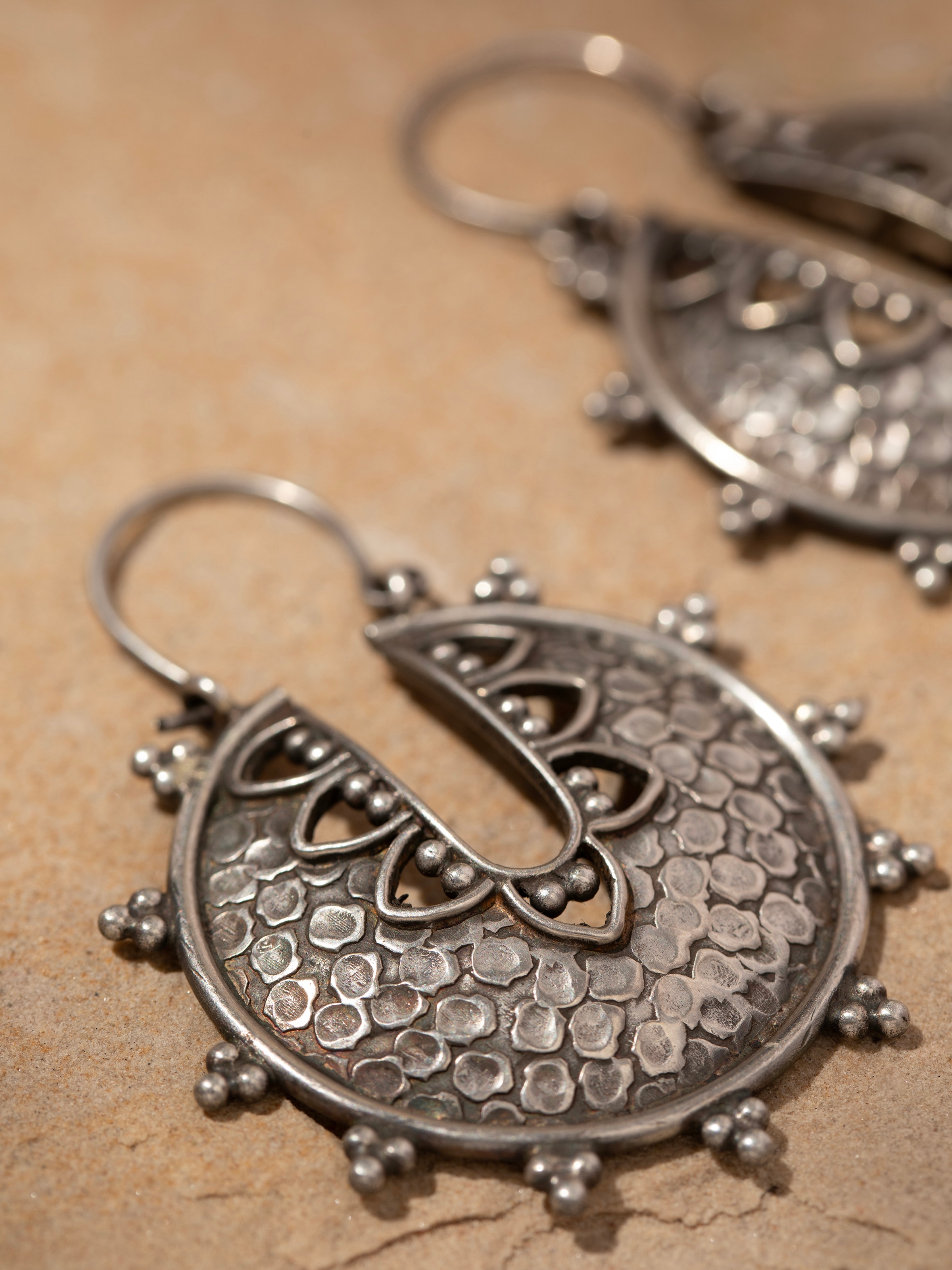 Detailed close-up of Smithing Hoop Earrings focusing on their refined metal texture and shine.