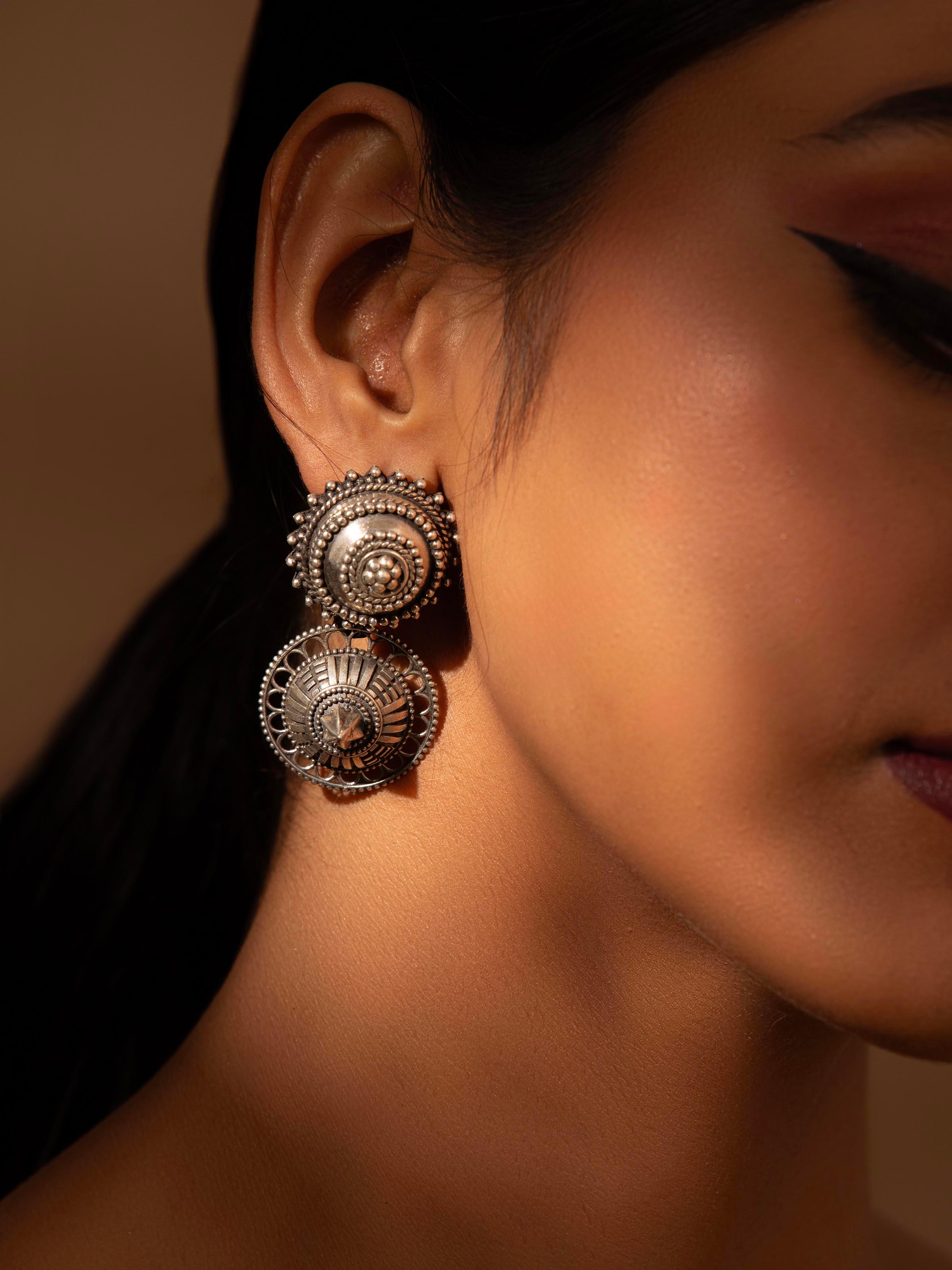 Close-up view of Silver Smithing Drop Earrings highlighting intricate silver detailing.