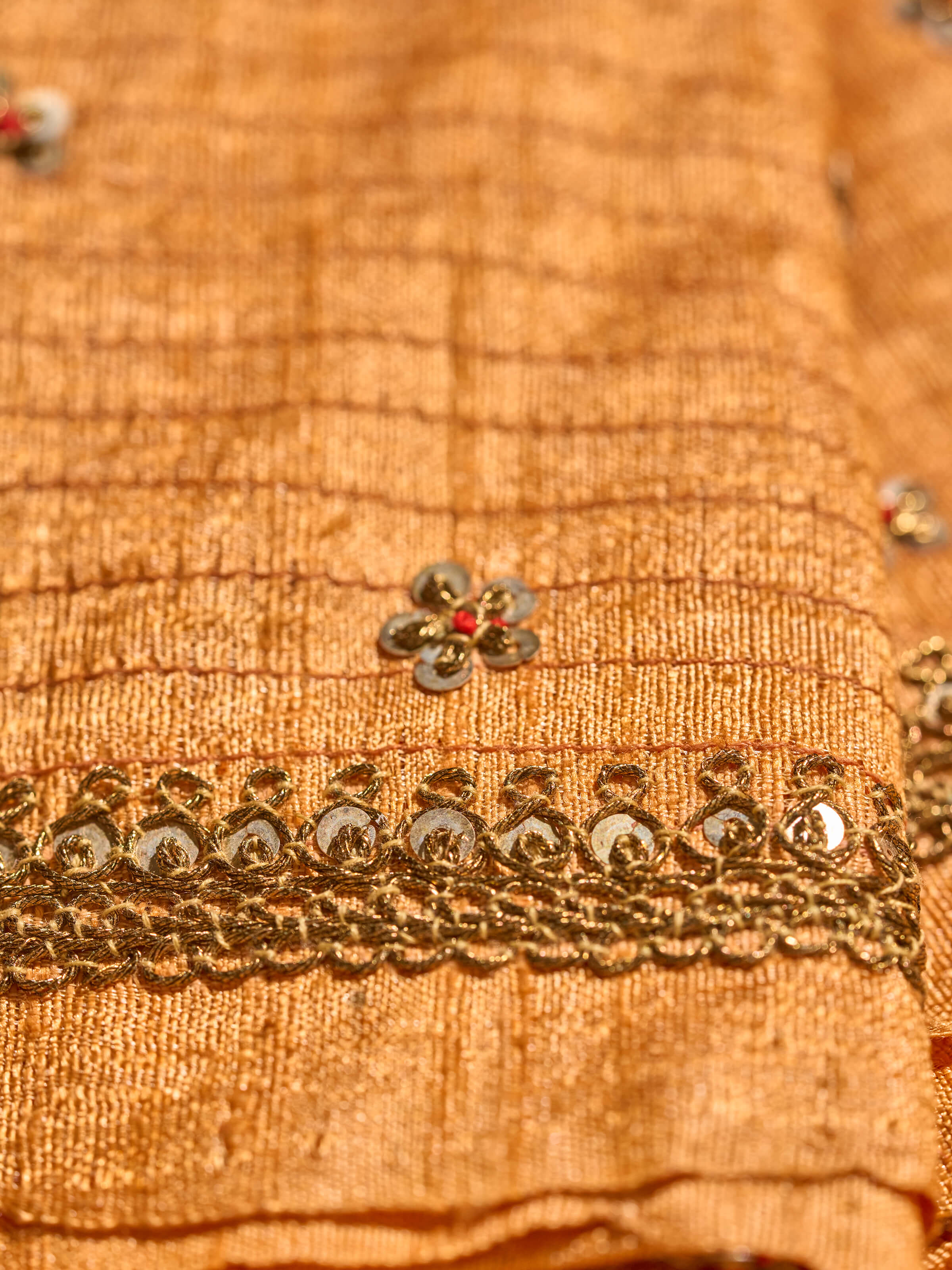 Angled view of Rust Tussar Silk Zardozi Embroidered Blouse Piece displaying embroidery and silk finish