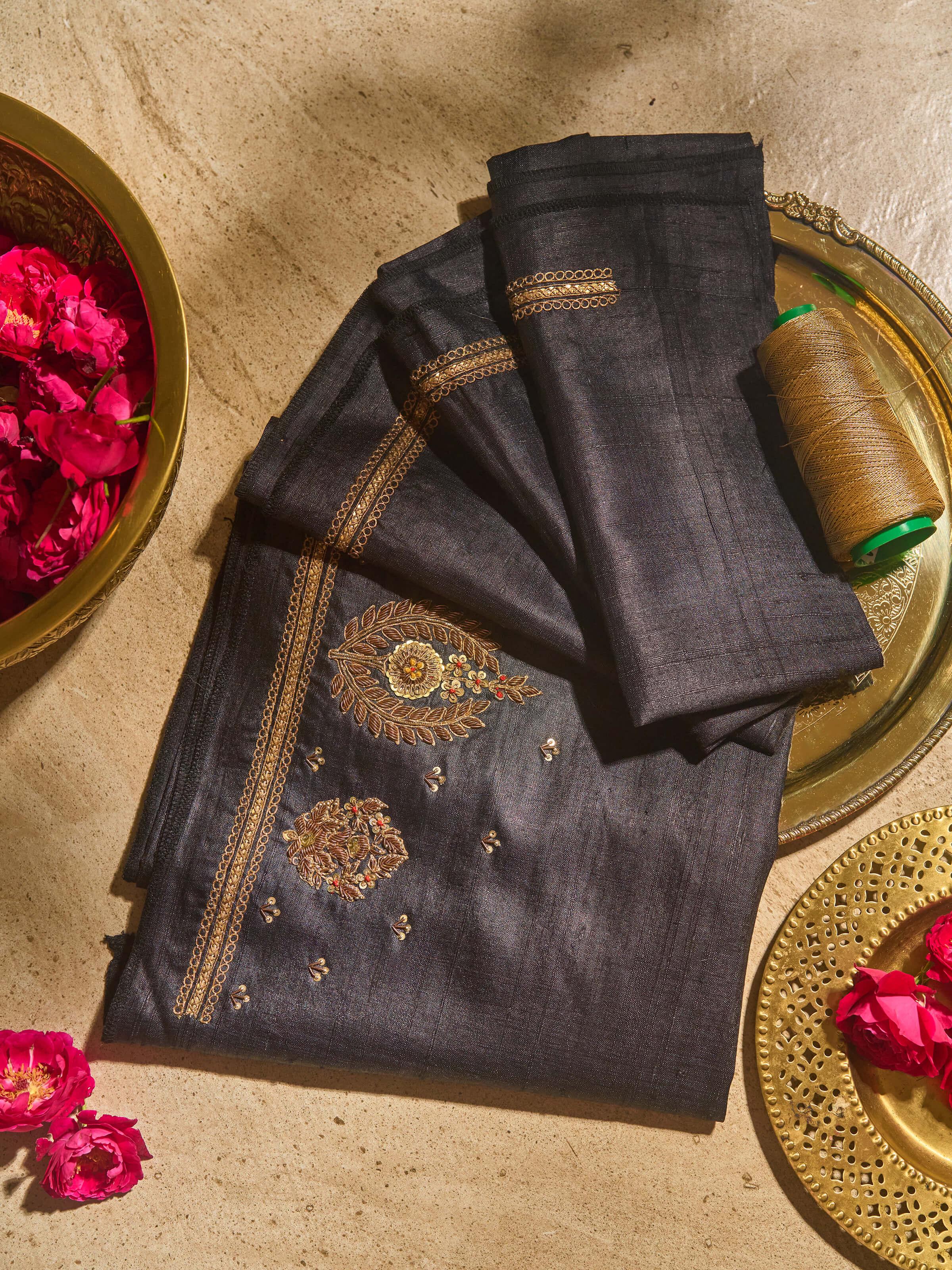 Lifestyle view of black Zardozi embroidered blouse fabric highlighting sheen and design placement.
