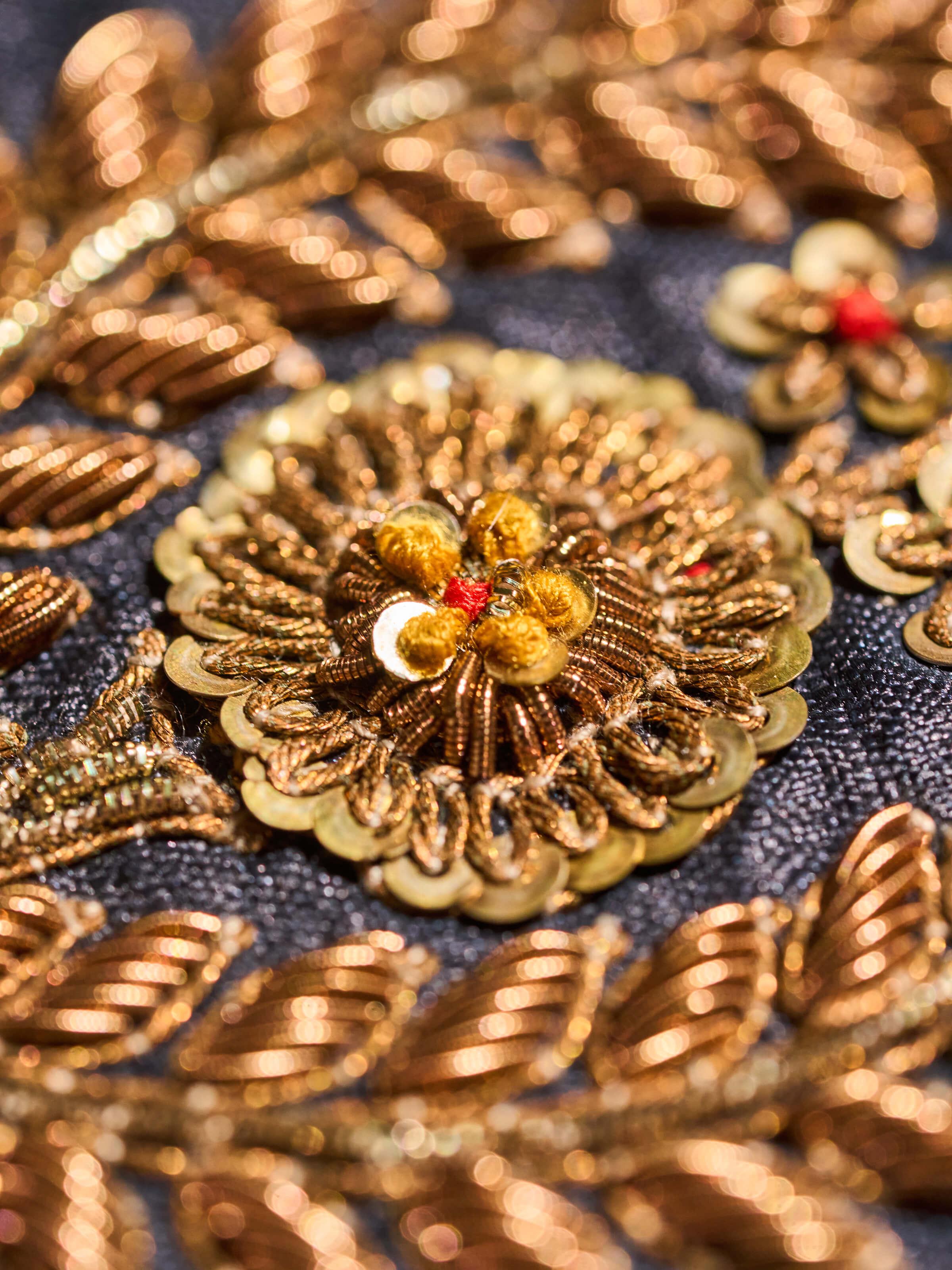 Close-up view of Zardozi blouse piece showing intricate floral motifs on textured silk.