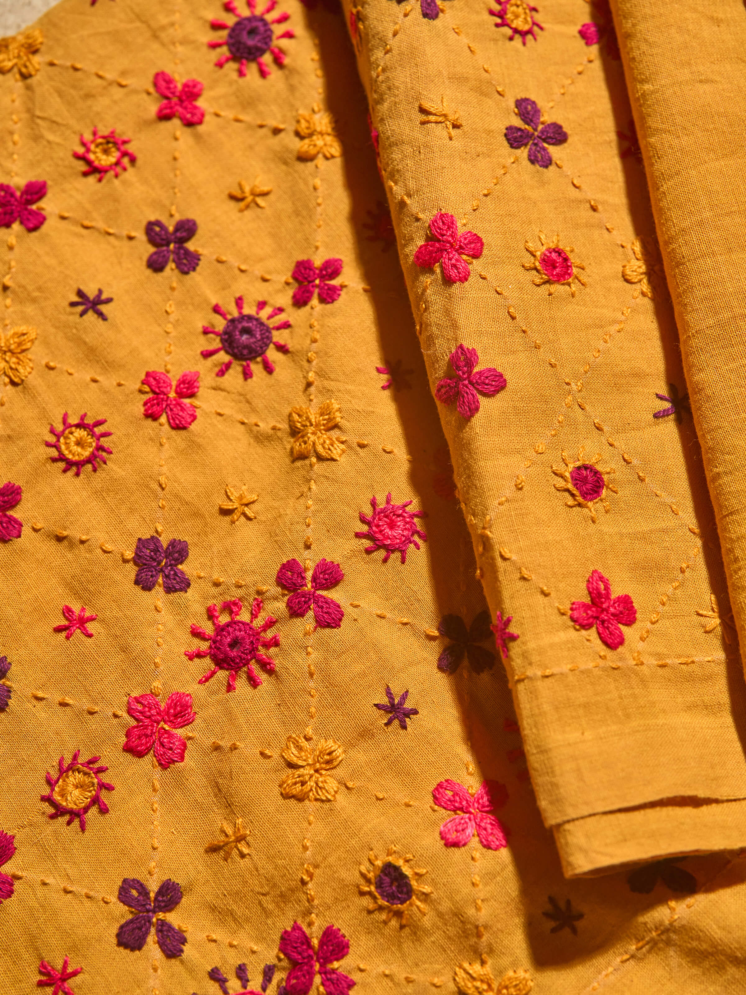 Close-up detail of colorful Lambani embroidery on blouse fabric.