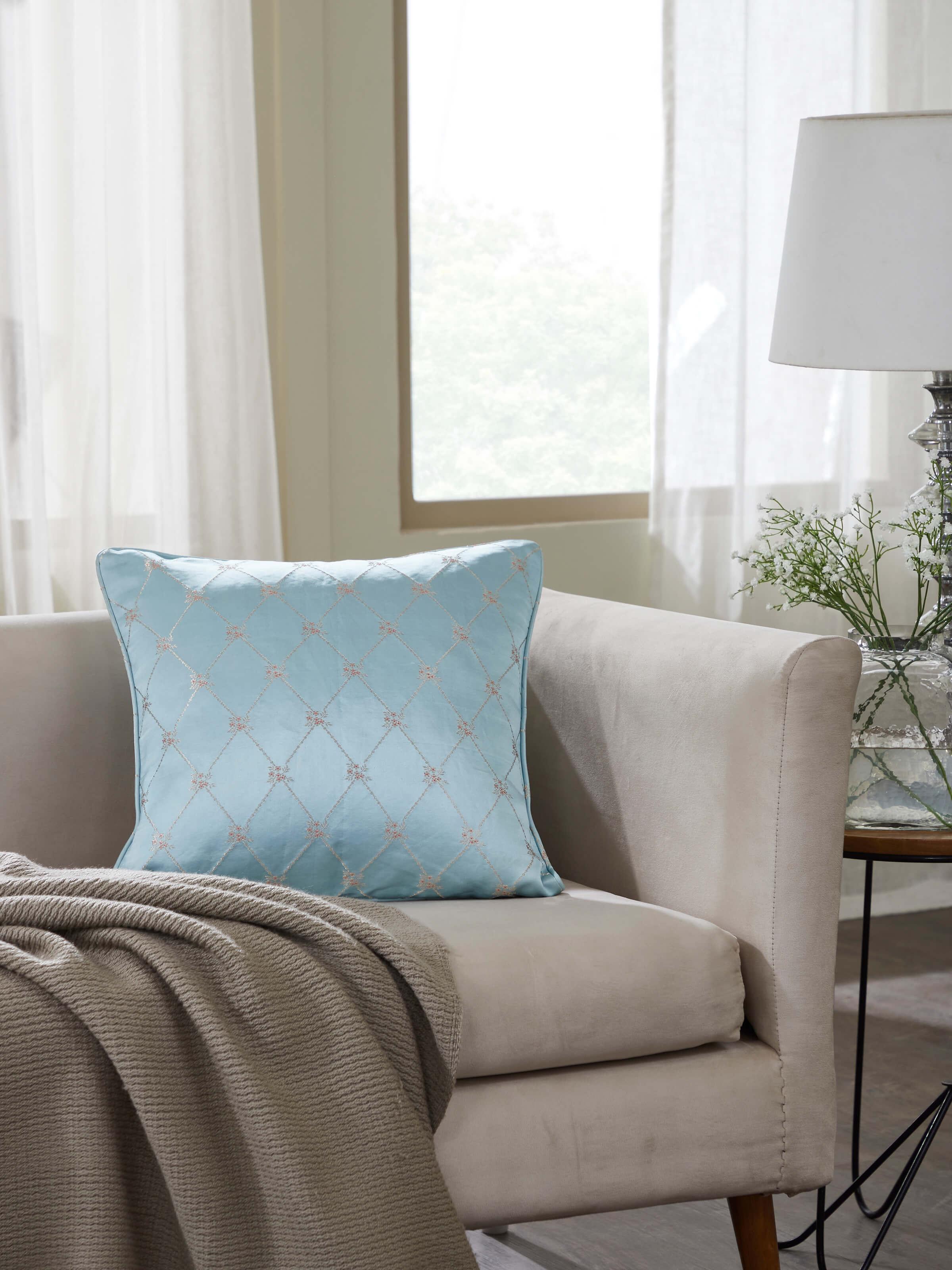 Lifestyle shot: Aqua silk cushion styled in elegant interior, showcasing traditional brocade detailing.