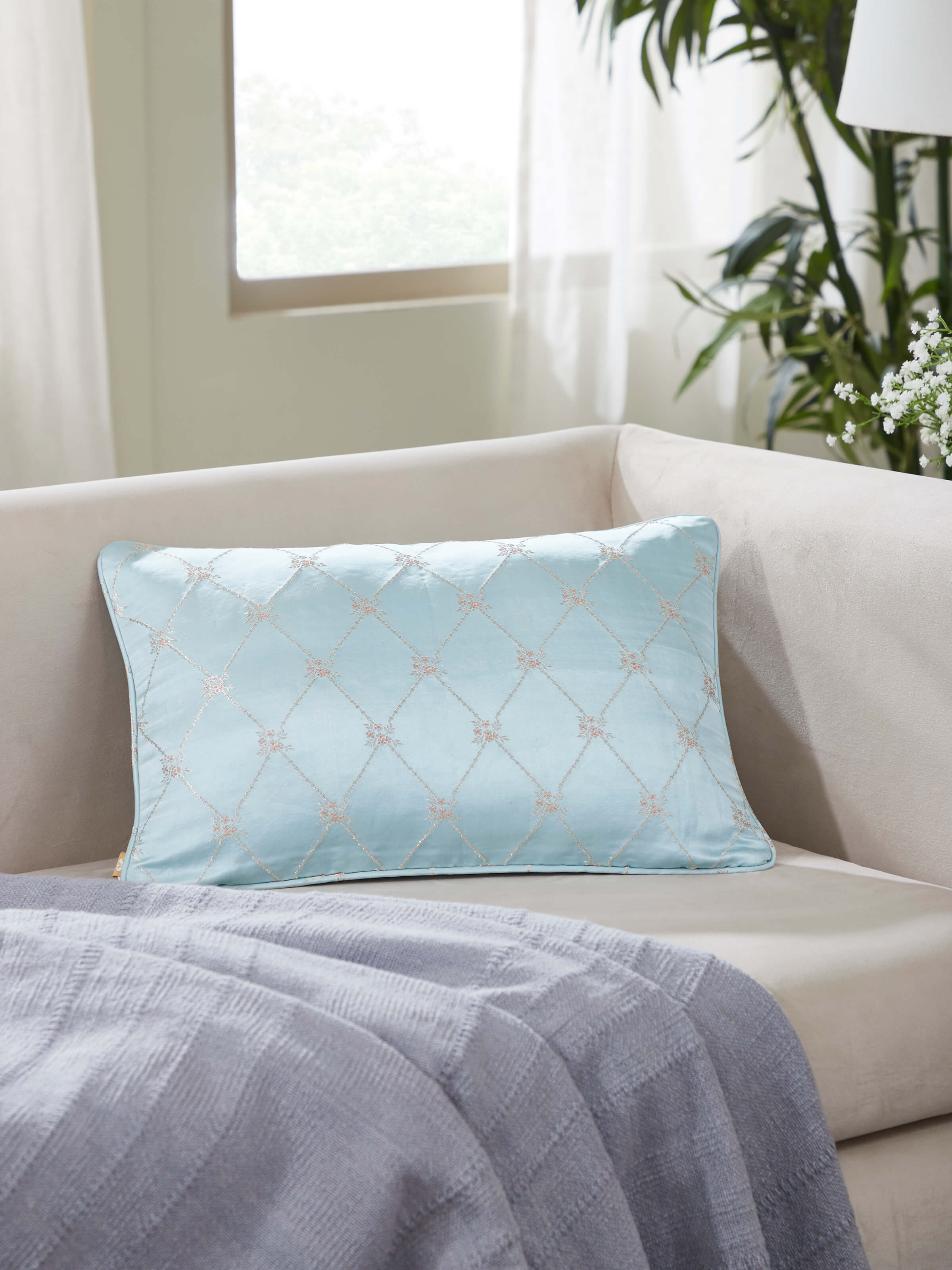 Sofa setup featuring silk lumbar cushion with traditional Banarasi artistry.