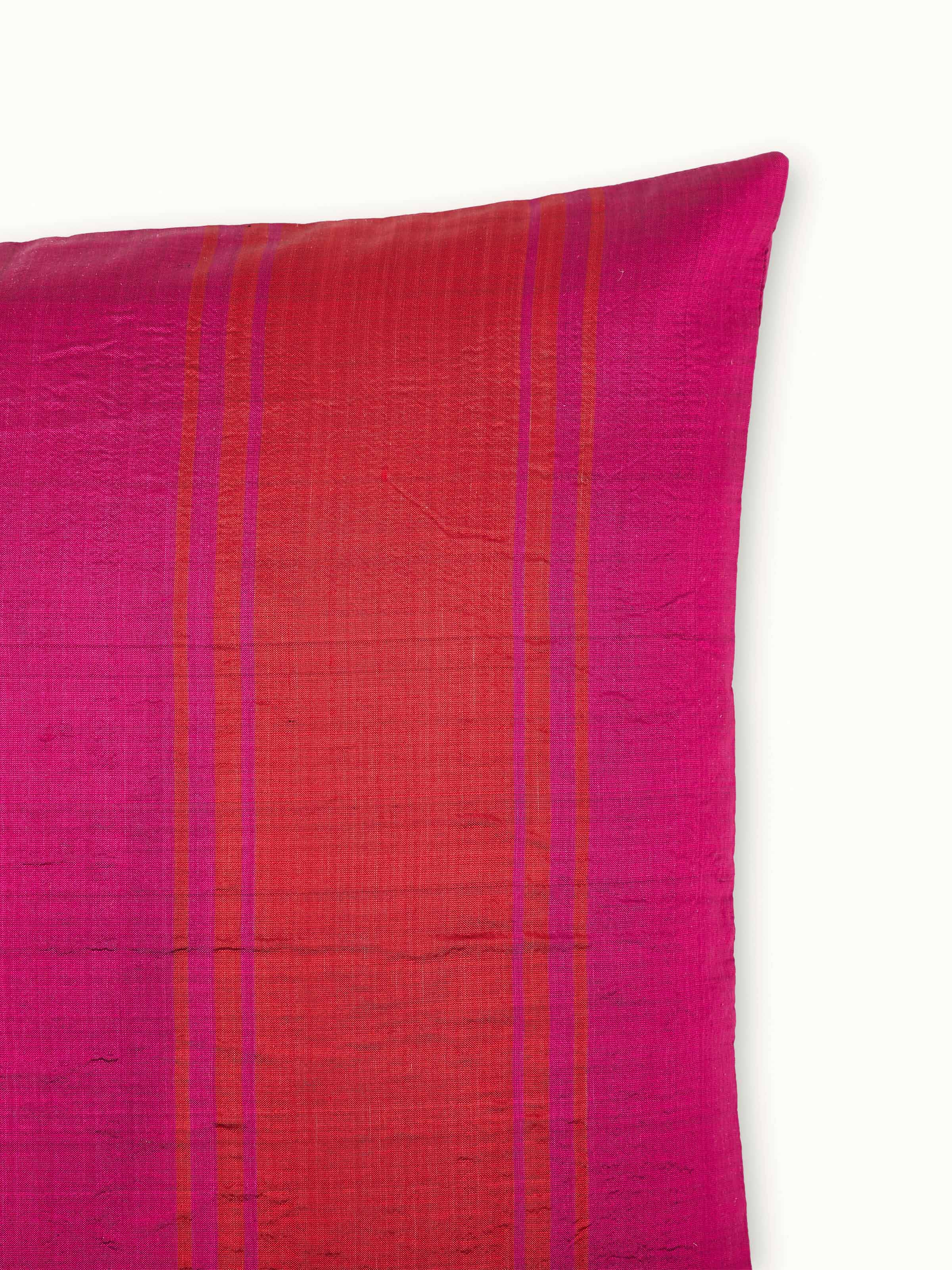 Bhoomi red wide stripe silk Odisha ikat handloom cushion cover displayed in a setting to highlight its design and use.