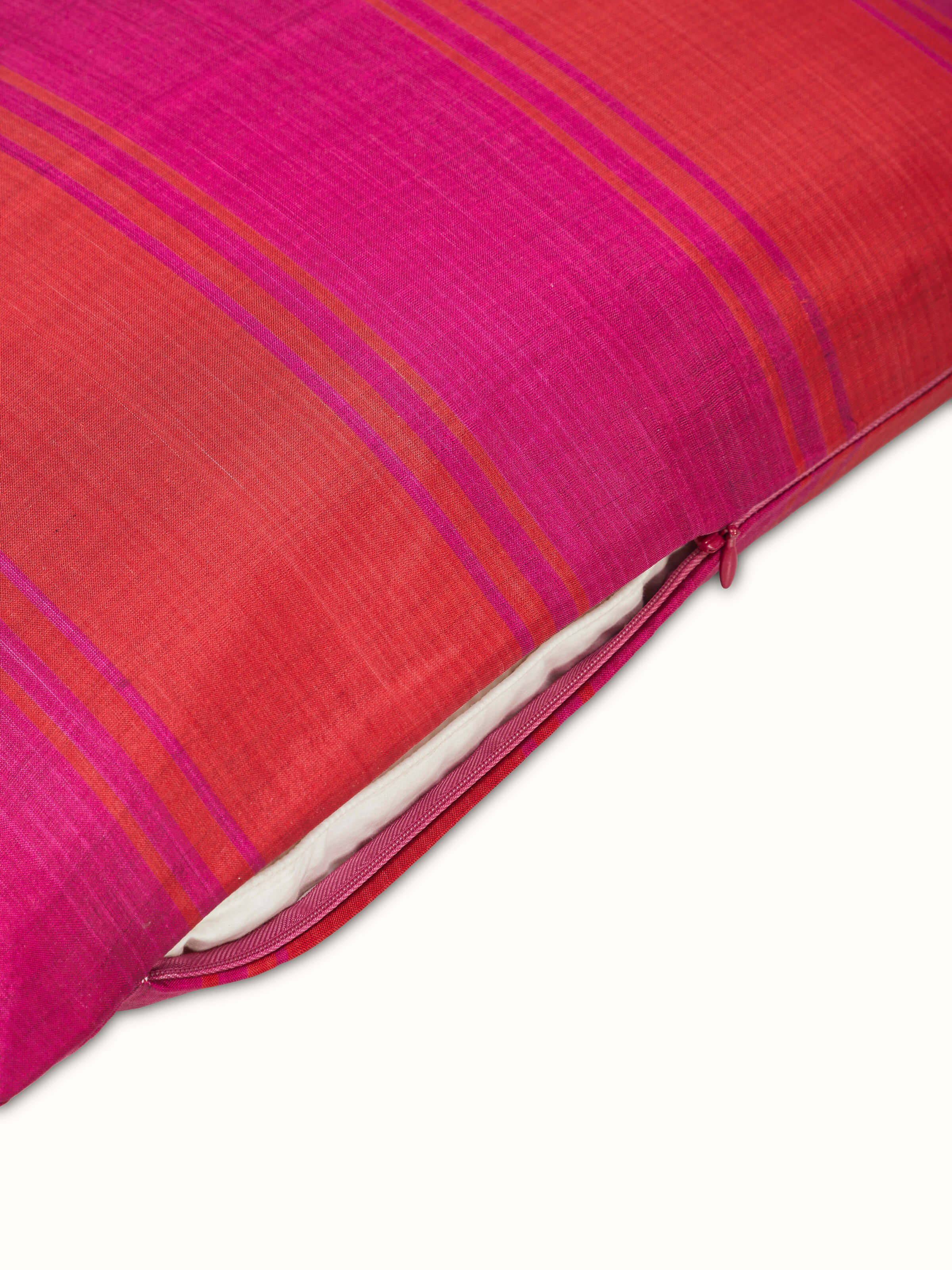 Bhoomi red wide stripe silk Odisha ikat handloom cushion cover folded to show the stripe pattern and silk texture.