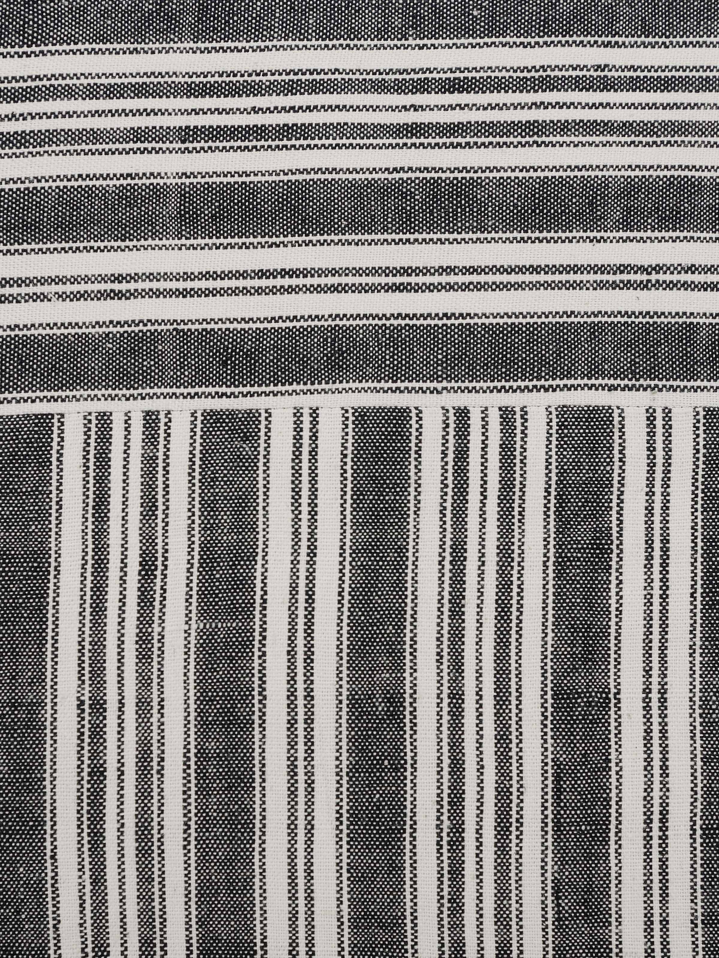 Ujjal black kaya cotton handloom cushion cover displayed on a sofa, demonstrating its practical use and elegant look.