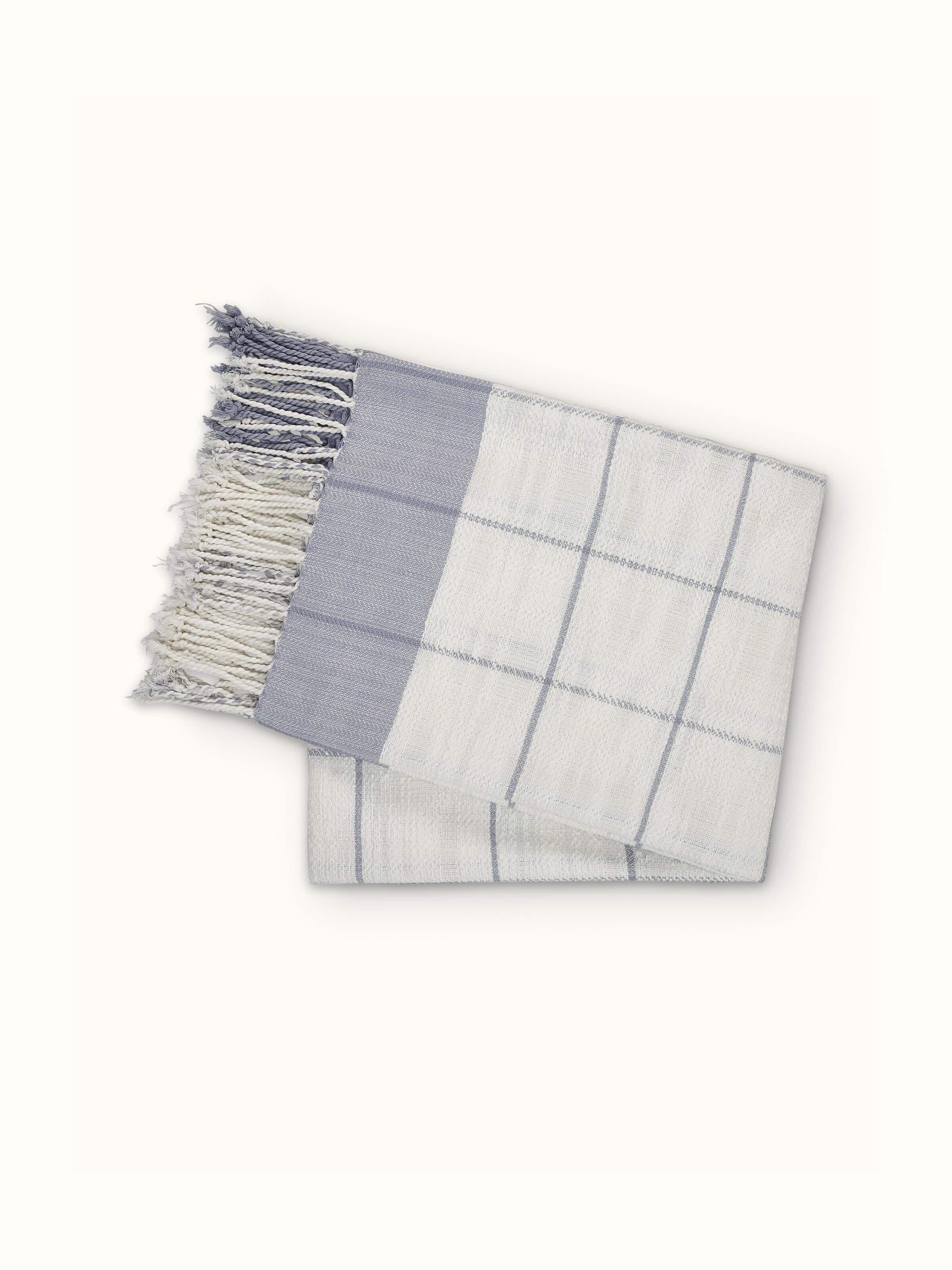 Lifestyle shot of Adhima grey twill cotton handloom throw in a cozy setting