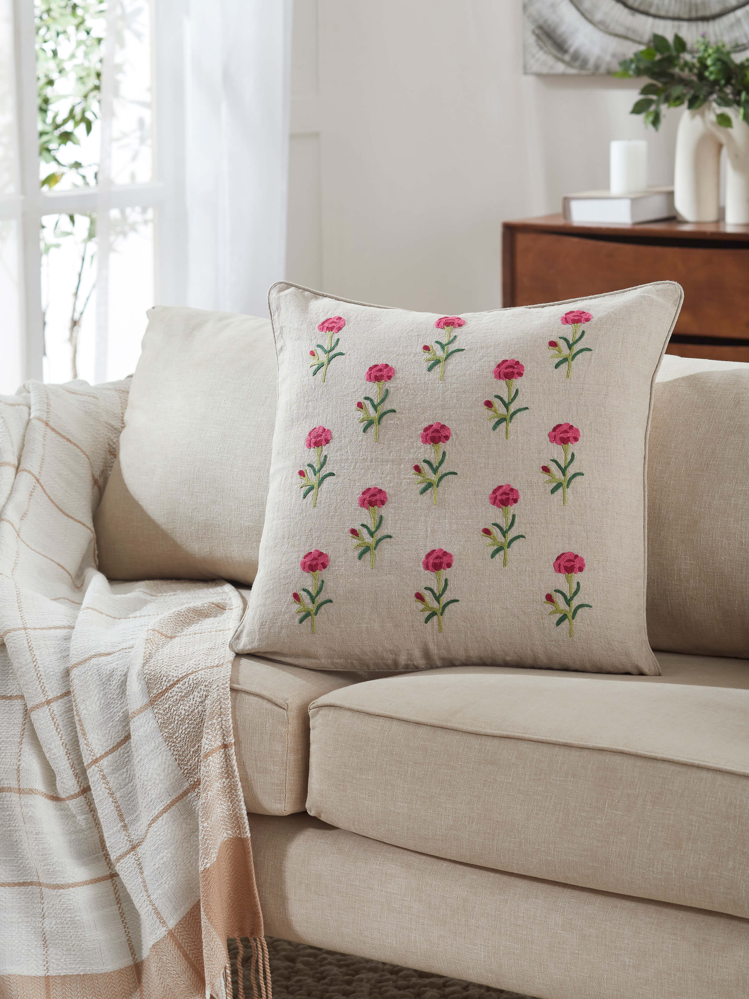 Close-up view of Mughal miniature magenta buti linen crewel hand embroidered cushion cover, showcasing detailed hand embroidery in magenta.