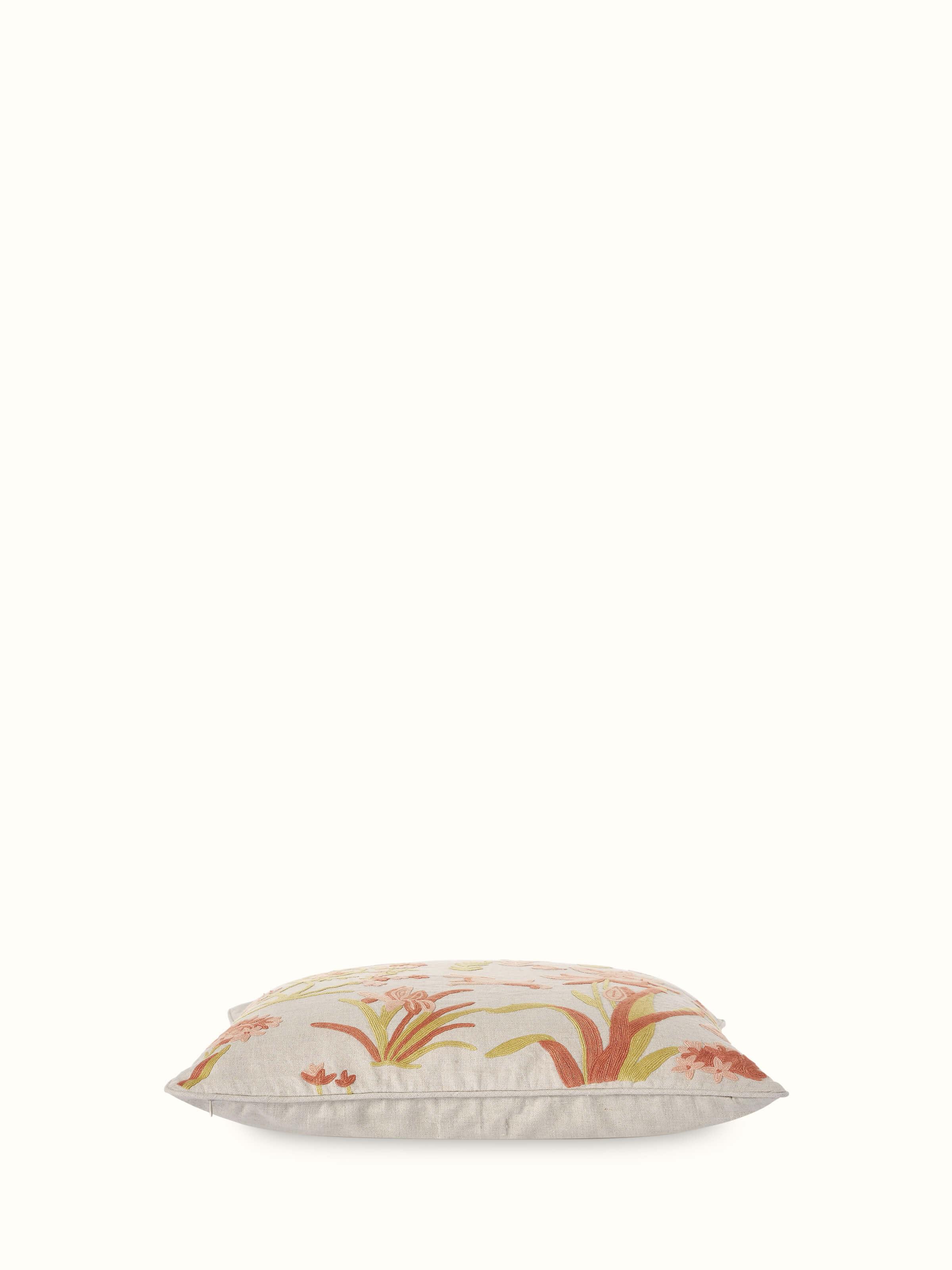 Angled view of Mansur Peach Allover Linen Crewel Hand Embroidered Cushion Cover showcasing its soft texture and vibrant embroidery