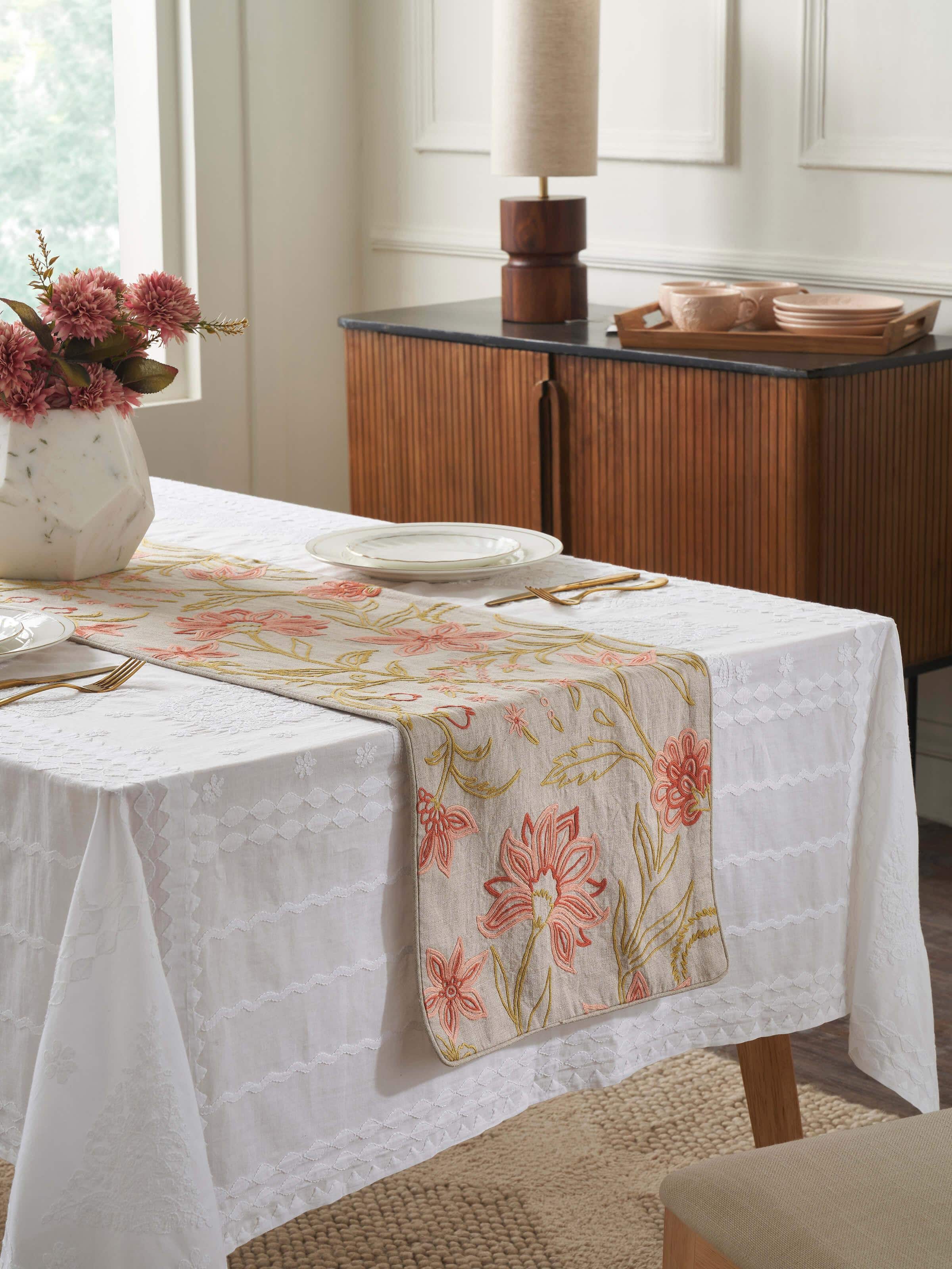 Lifestyle shot of embroidered runner styled on a dining table, creating a refined look.