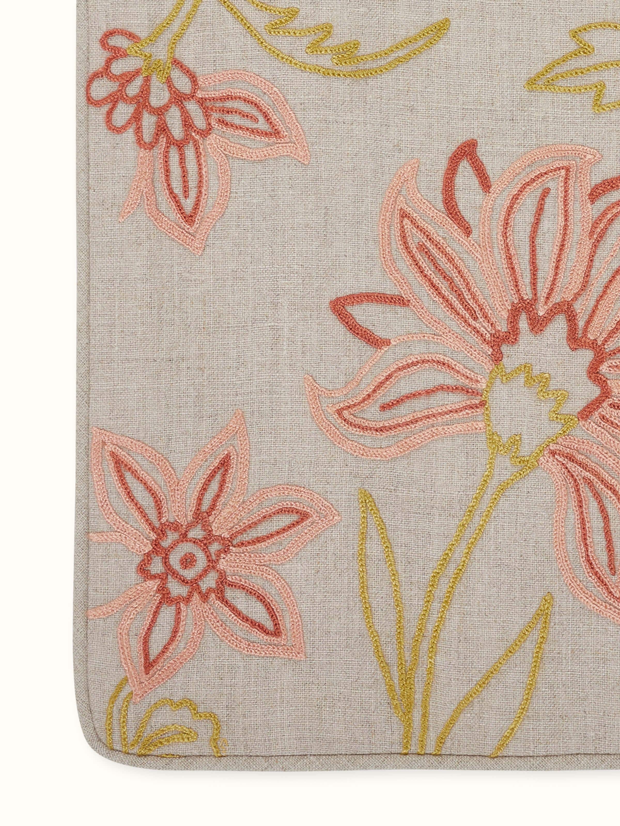 Detail shot of finely stitched chain embroidery motifs on soft linen.