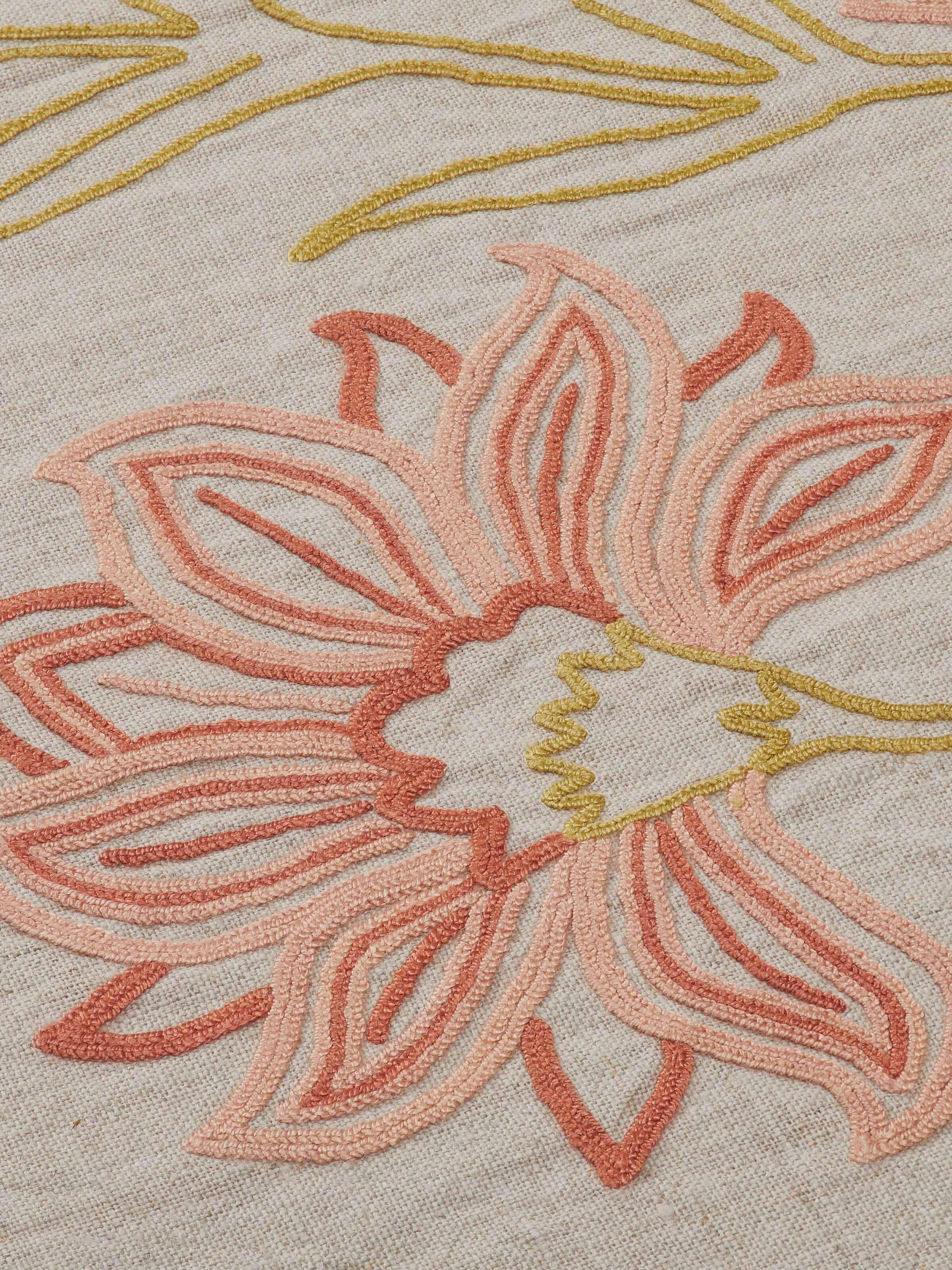 Detail shot of textured linen weave with embroidered accents.