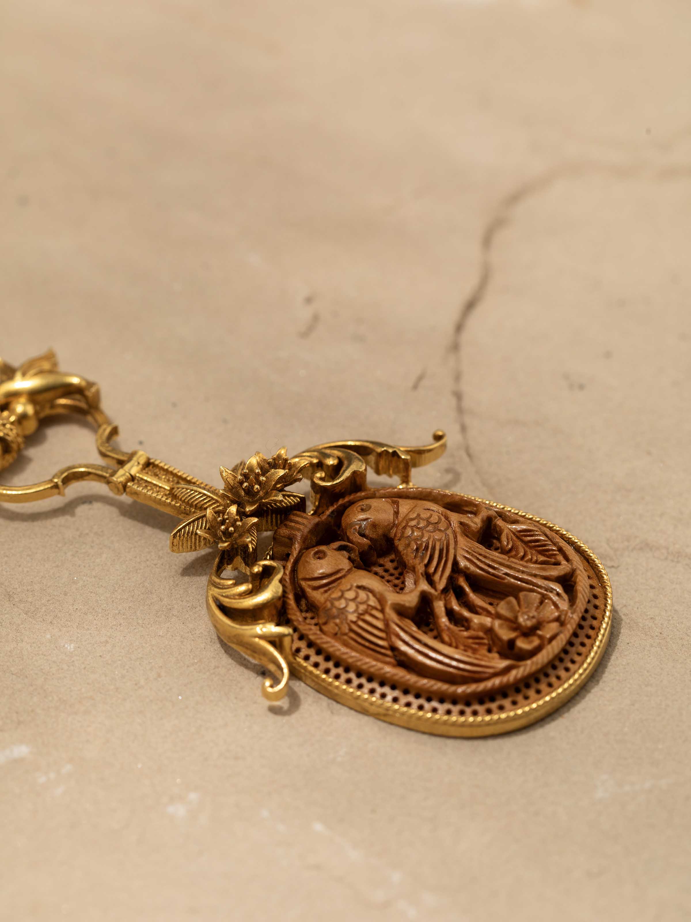 Detail shot capturing engraved silverwork and smooth wooden beads