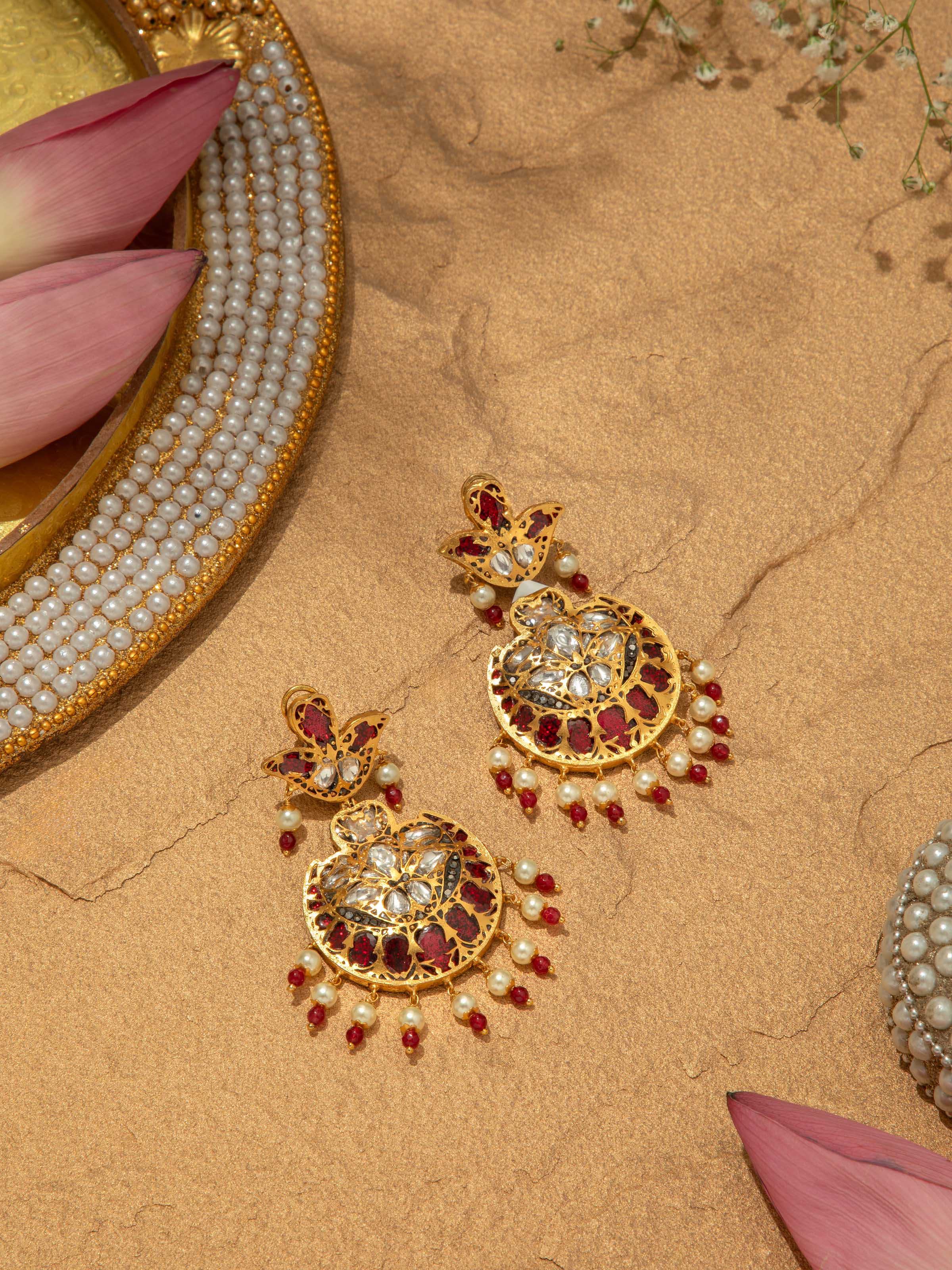 Angled view of Bandhel metal drop earrings with unique design elements