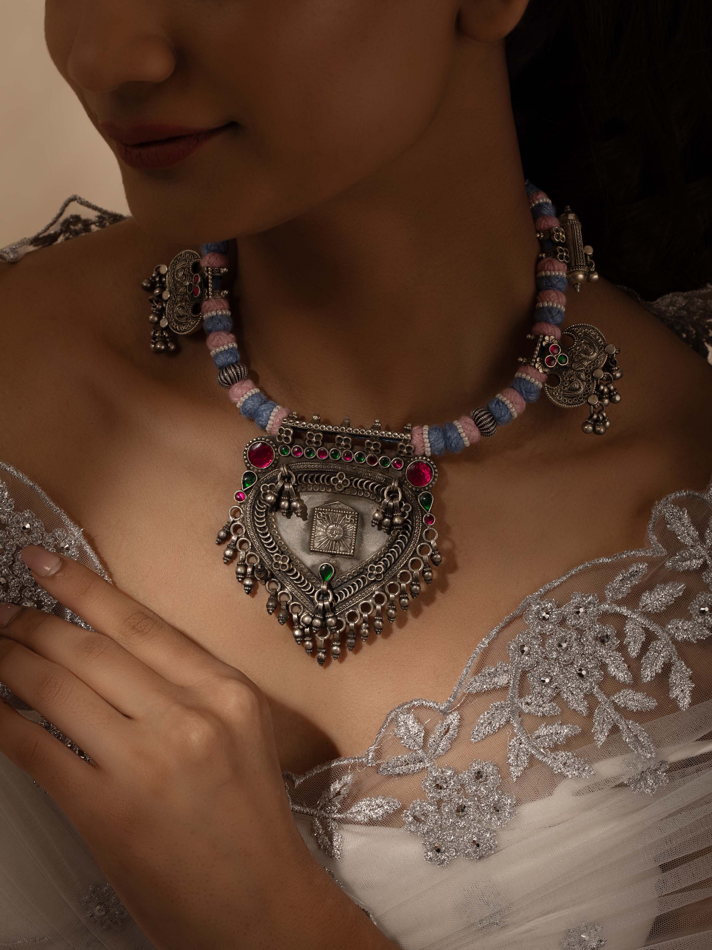 Side view of silver smithing collar necklace showing its design and elegant curve