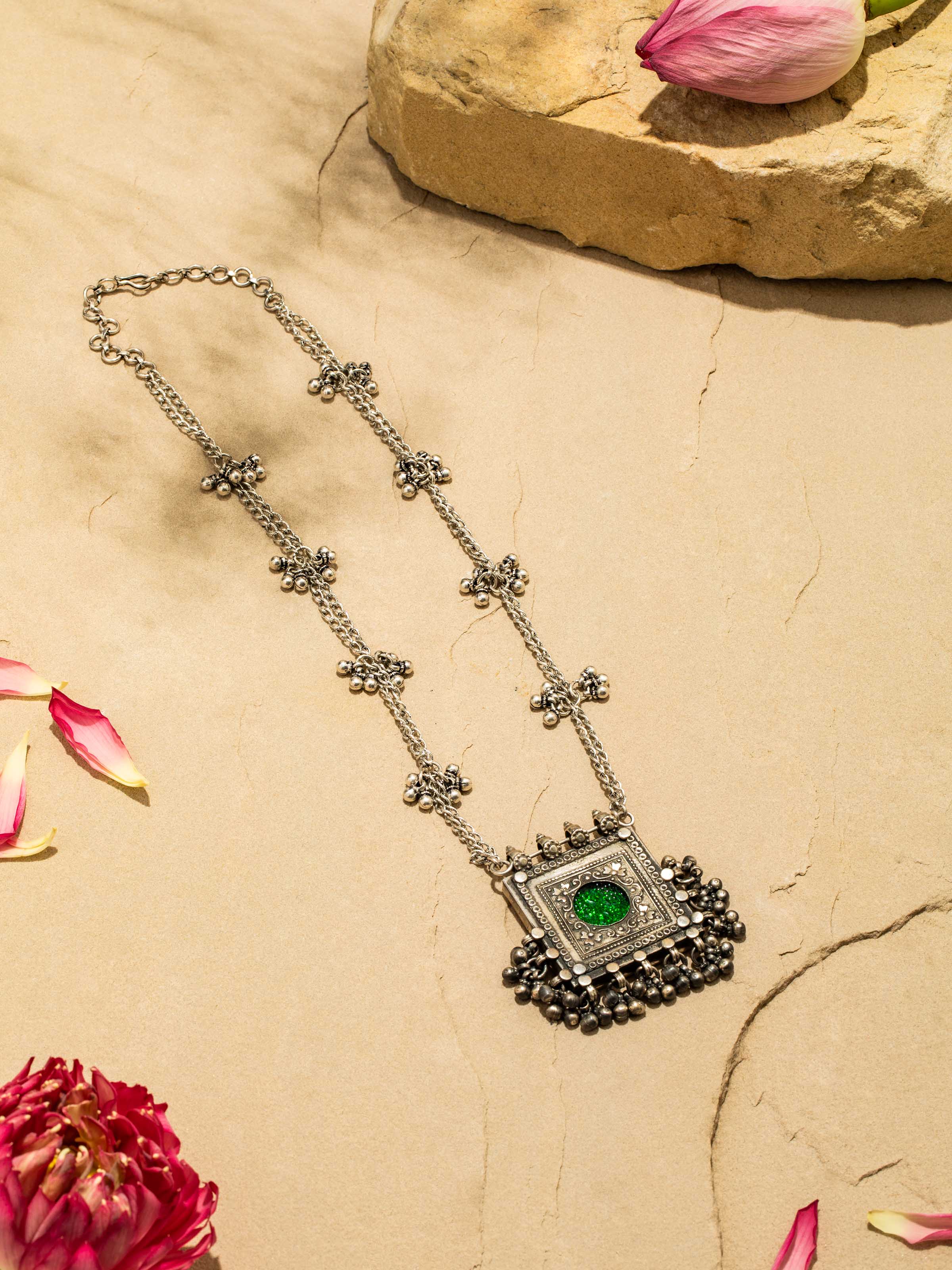 Top view of intricately crafted silver smithing long necklace featuring a detailed designer pendant suspended from a fine silver chain.