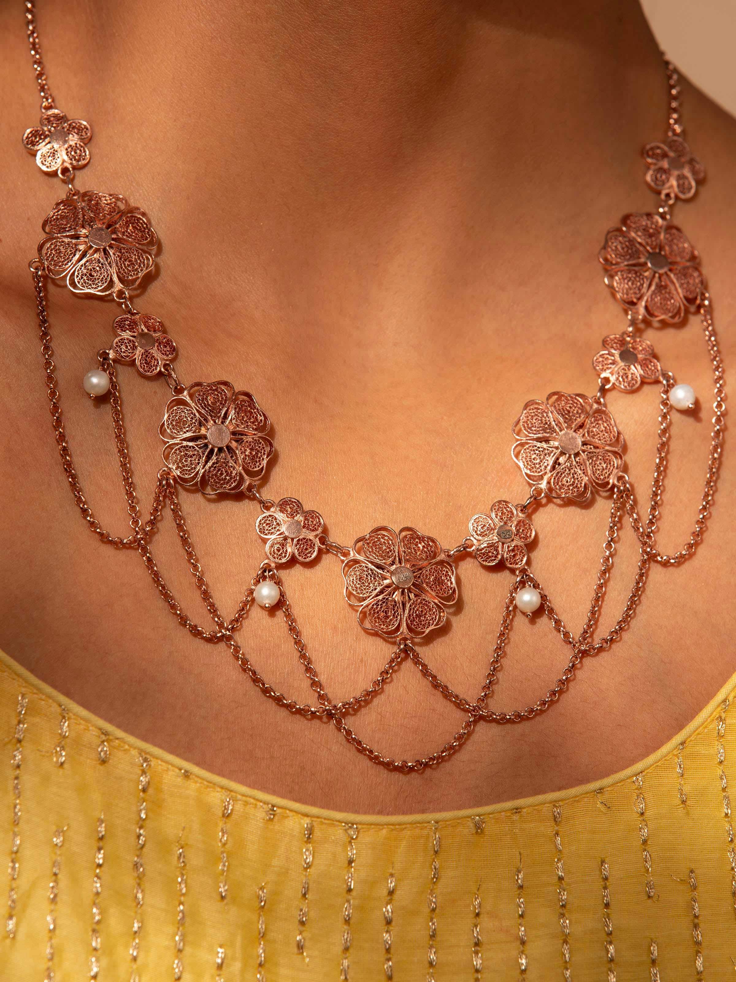 Close-up view of silver filigree collar necklace highlighting fine craftsmanship.