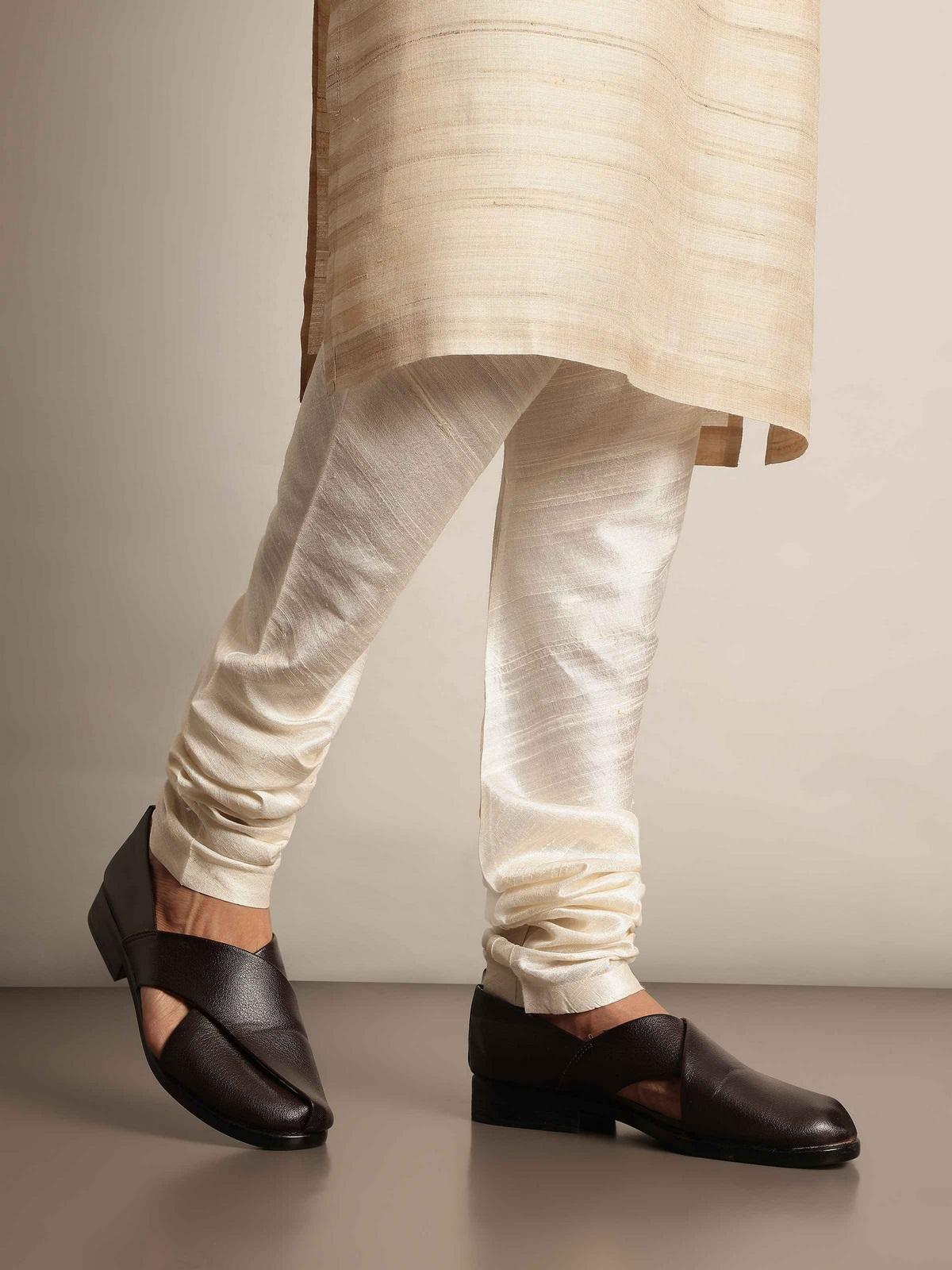 Lifestyle image of model wearing white silk churidar with elastic waistband and tapered legs.