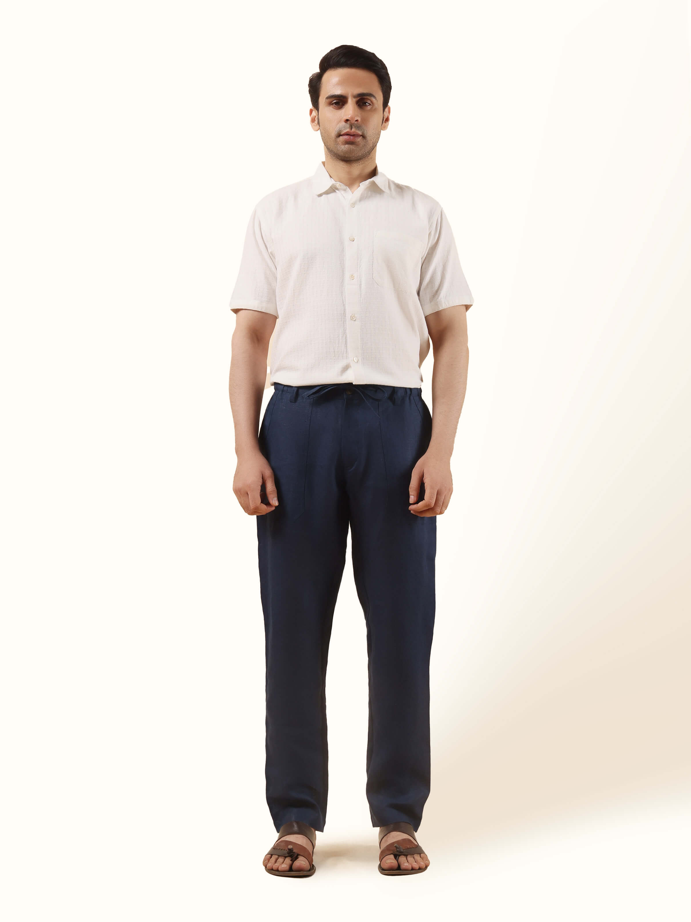 Front view of navy blue linen elasticated pant featuring a relaxed fit with a tapered silhouette and minimal detailing.