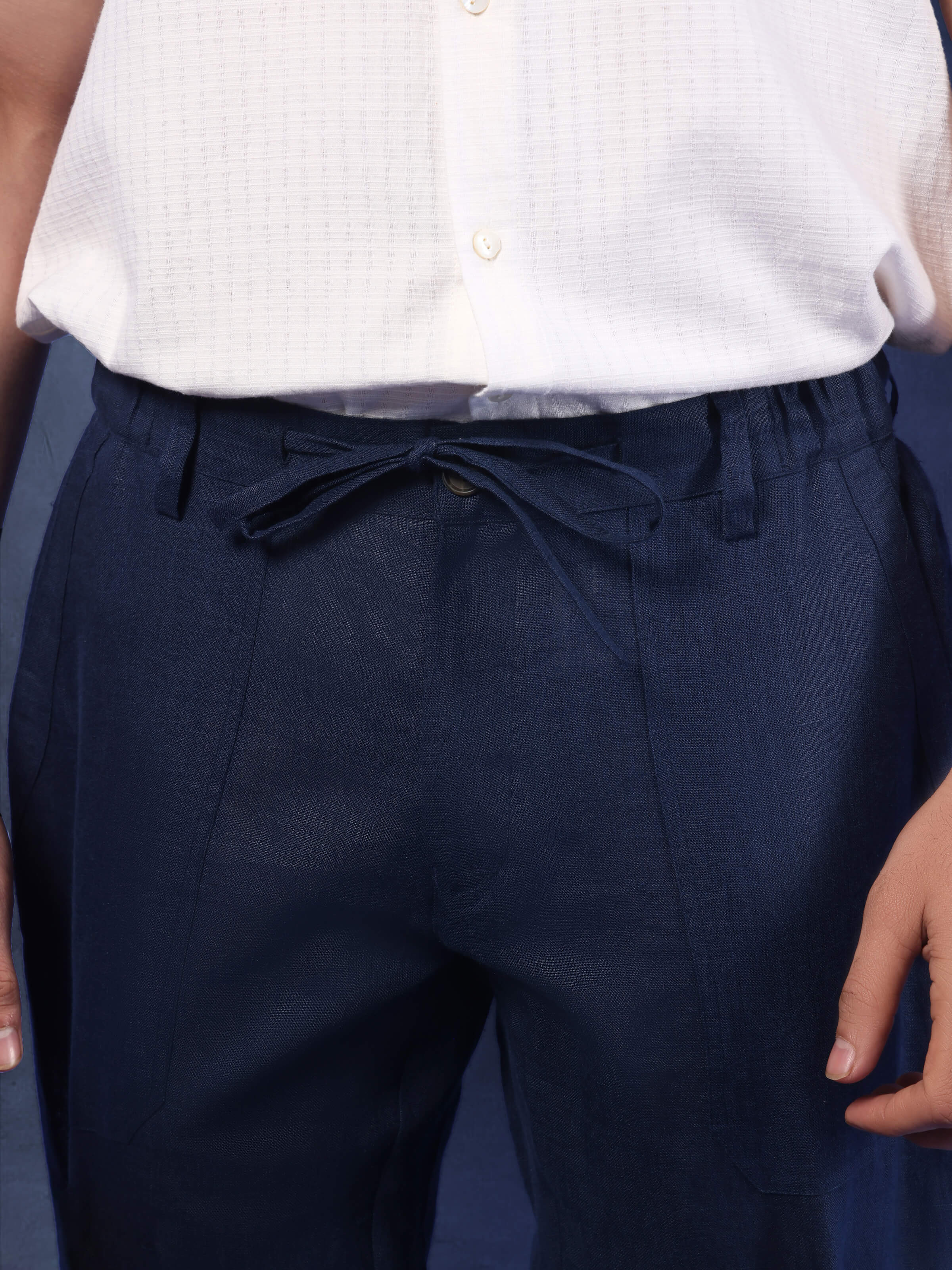 Detail shot of navy blue linen elasticated pant showing texture and neat stitching at the waist and pocket.