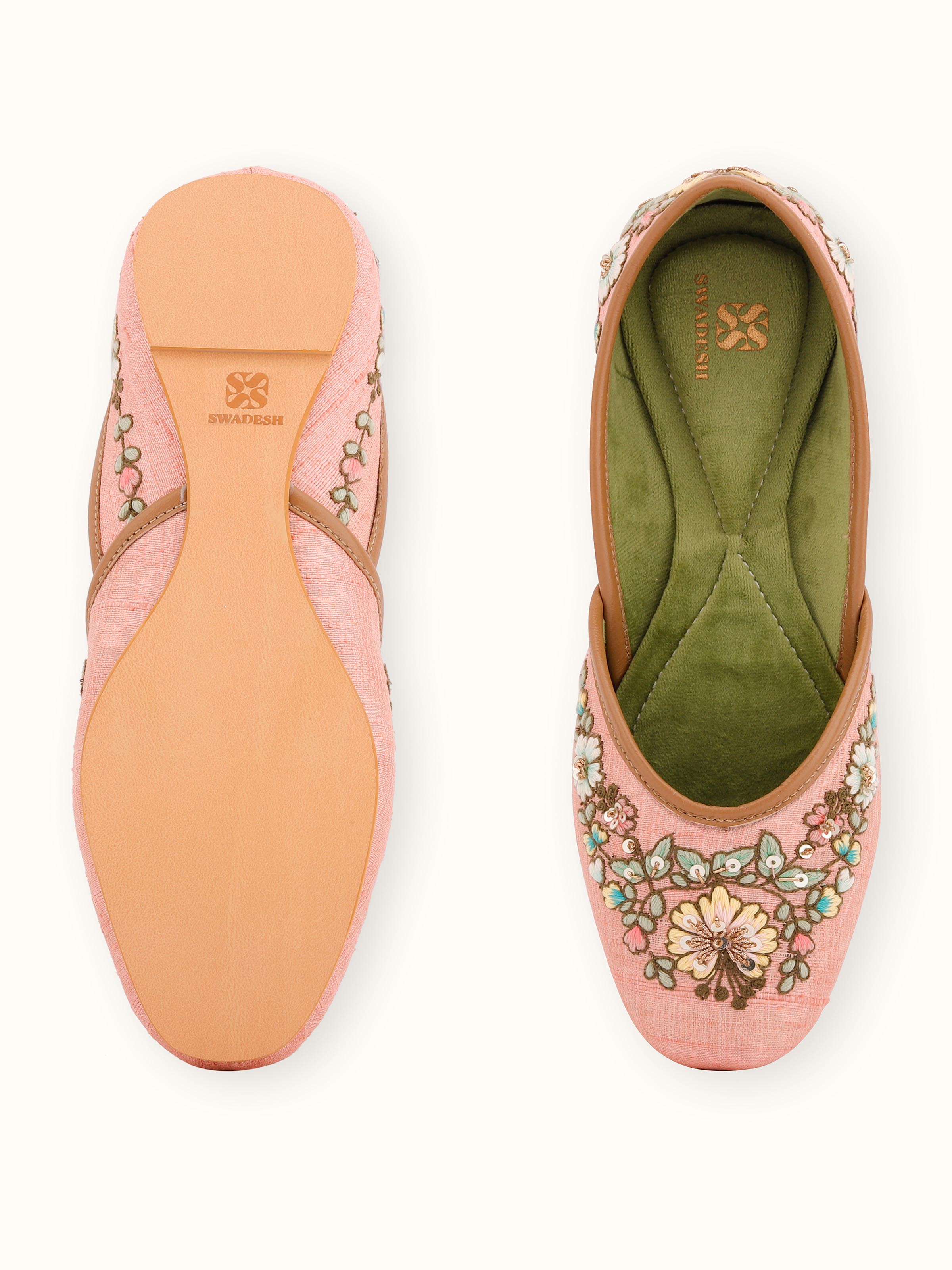 Detailed view of pink leather zardozi juttis with focus on the embroidery patterns