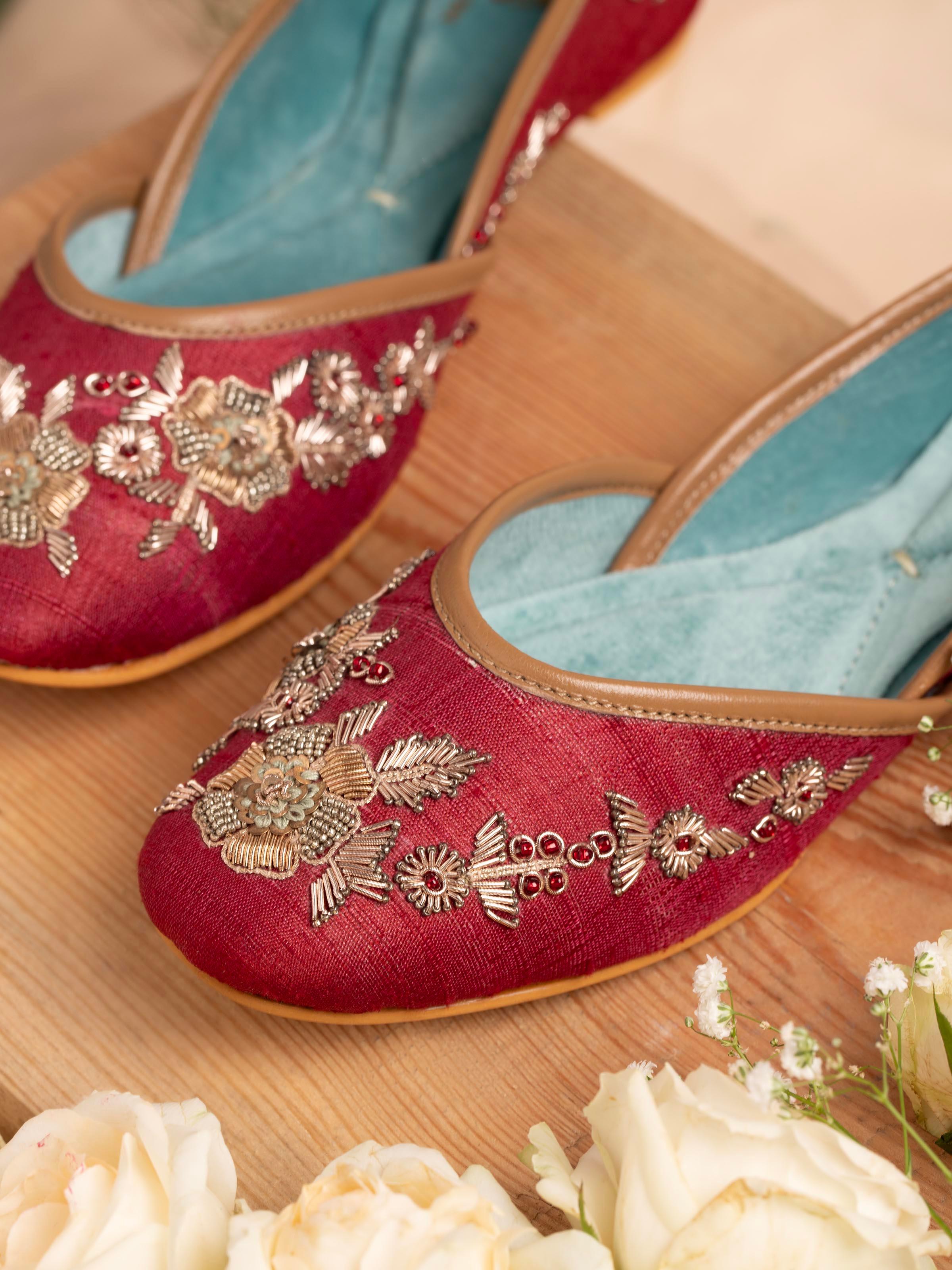 Close-up of maroon leather zardozi juttis showcasing detailed embroidery work