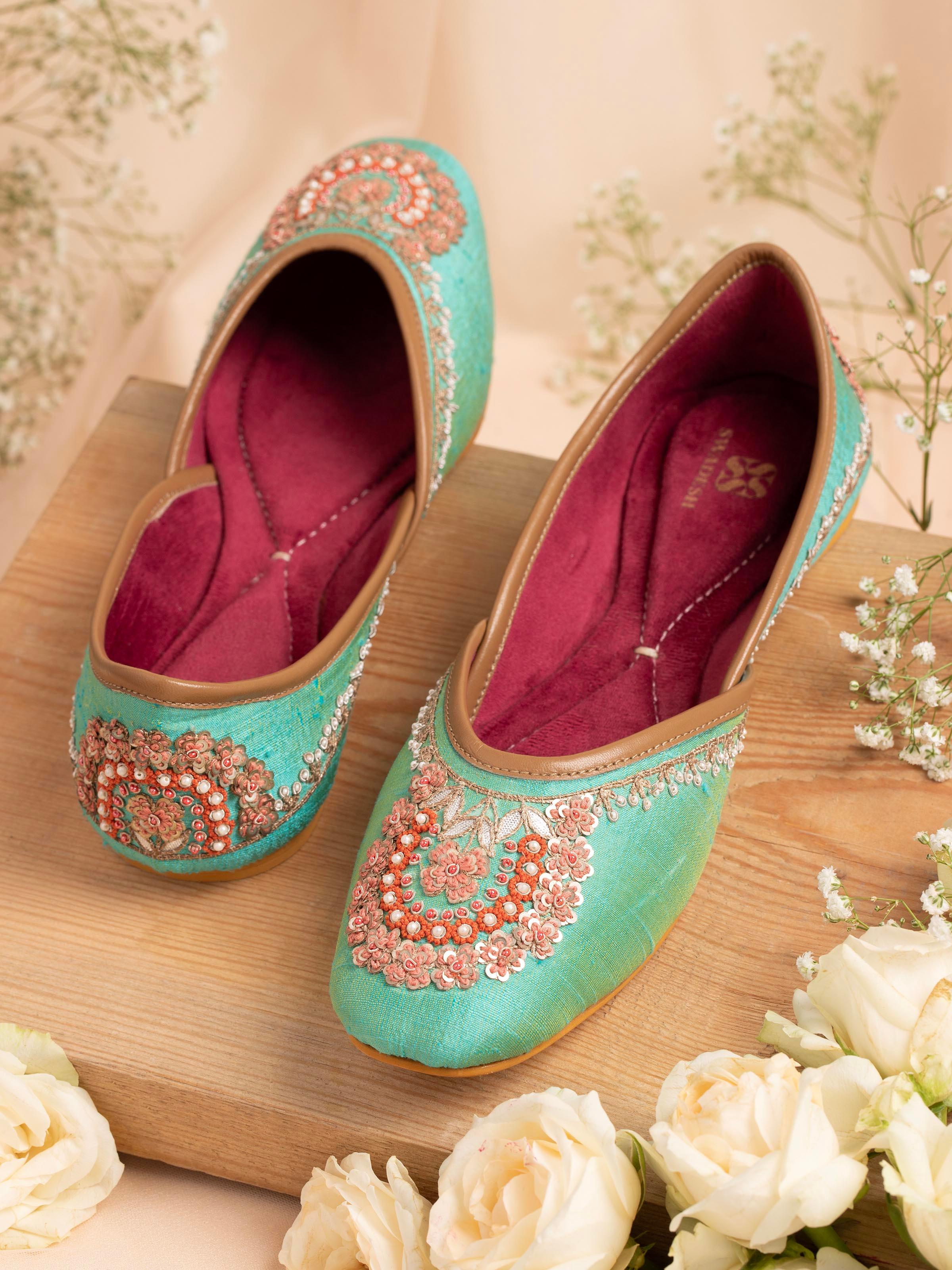 Side view of turquoise leather zardozi juttis emphasizing the intricate embroidery and leather details