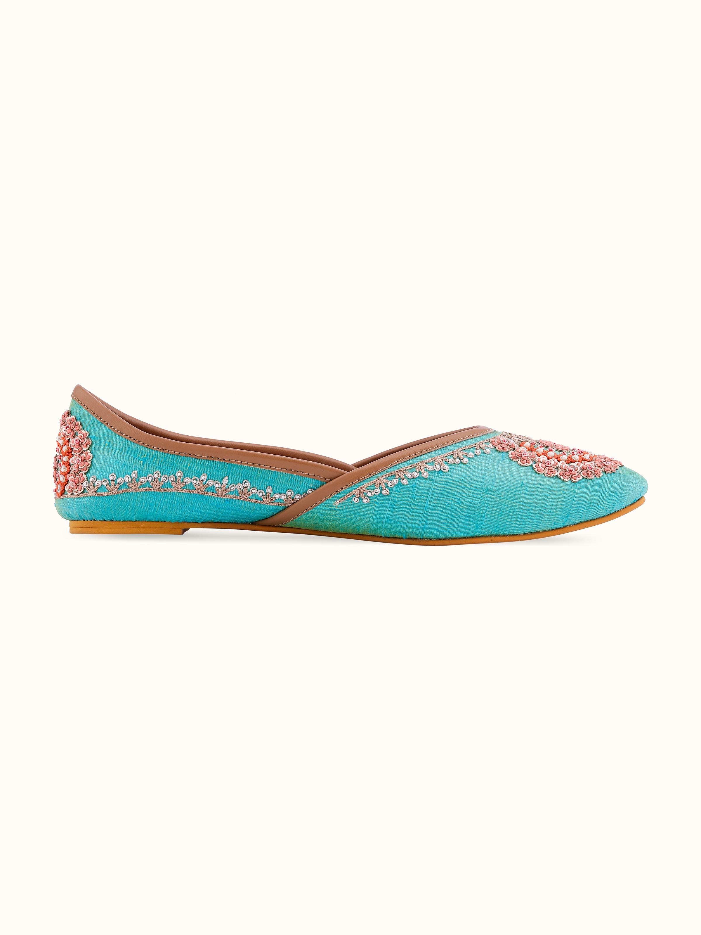 Angled view of turquoise leather zardozi juttis showcasing the design and craftsmanship