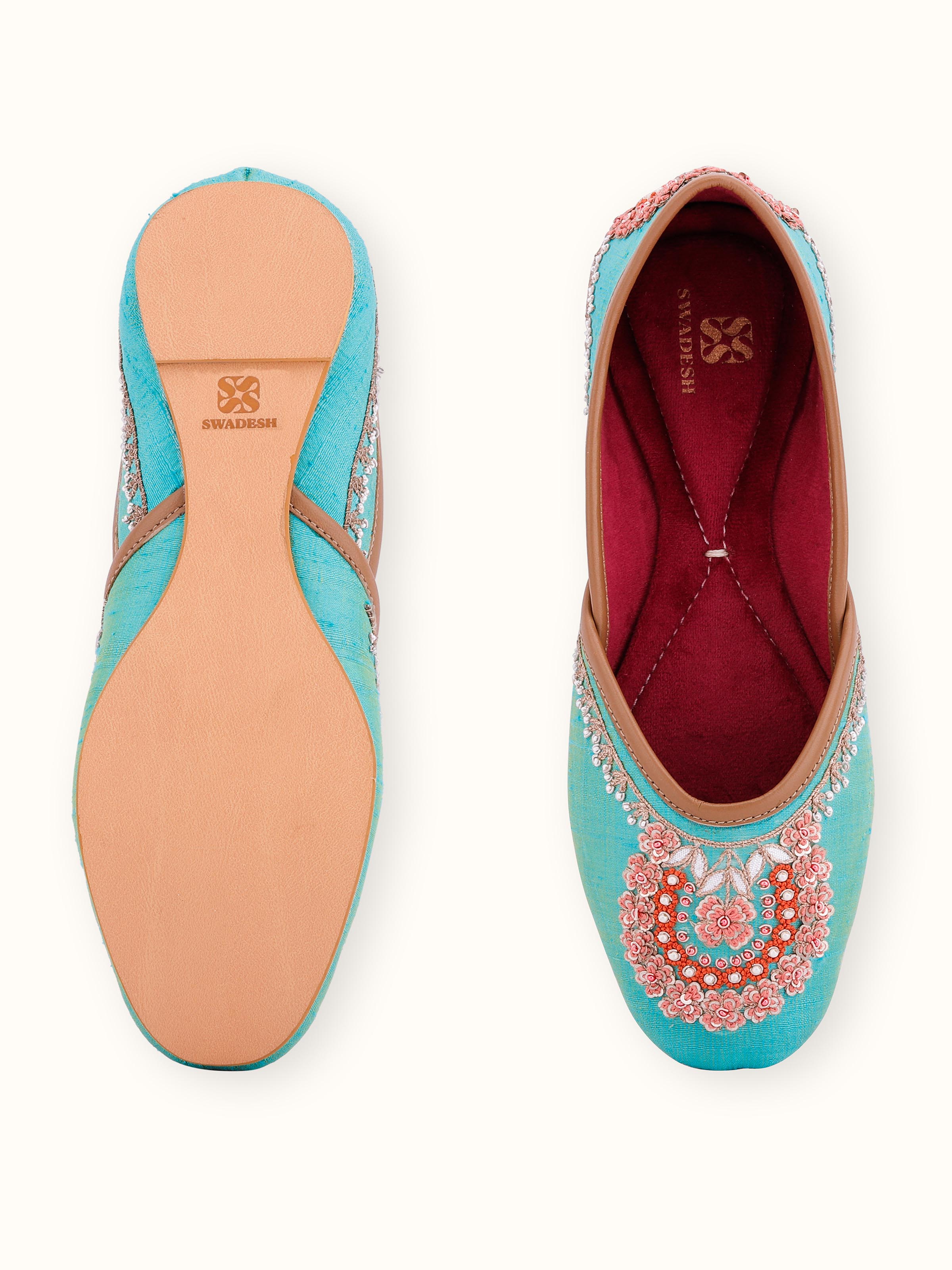 Close-up of turquoise leather zardozi juttis highlighting the intricate zardozi work and texture