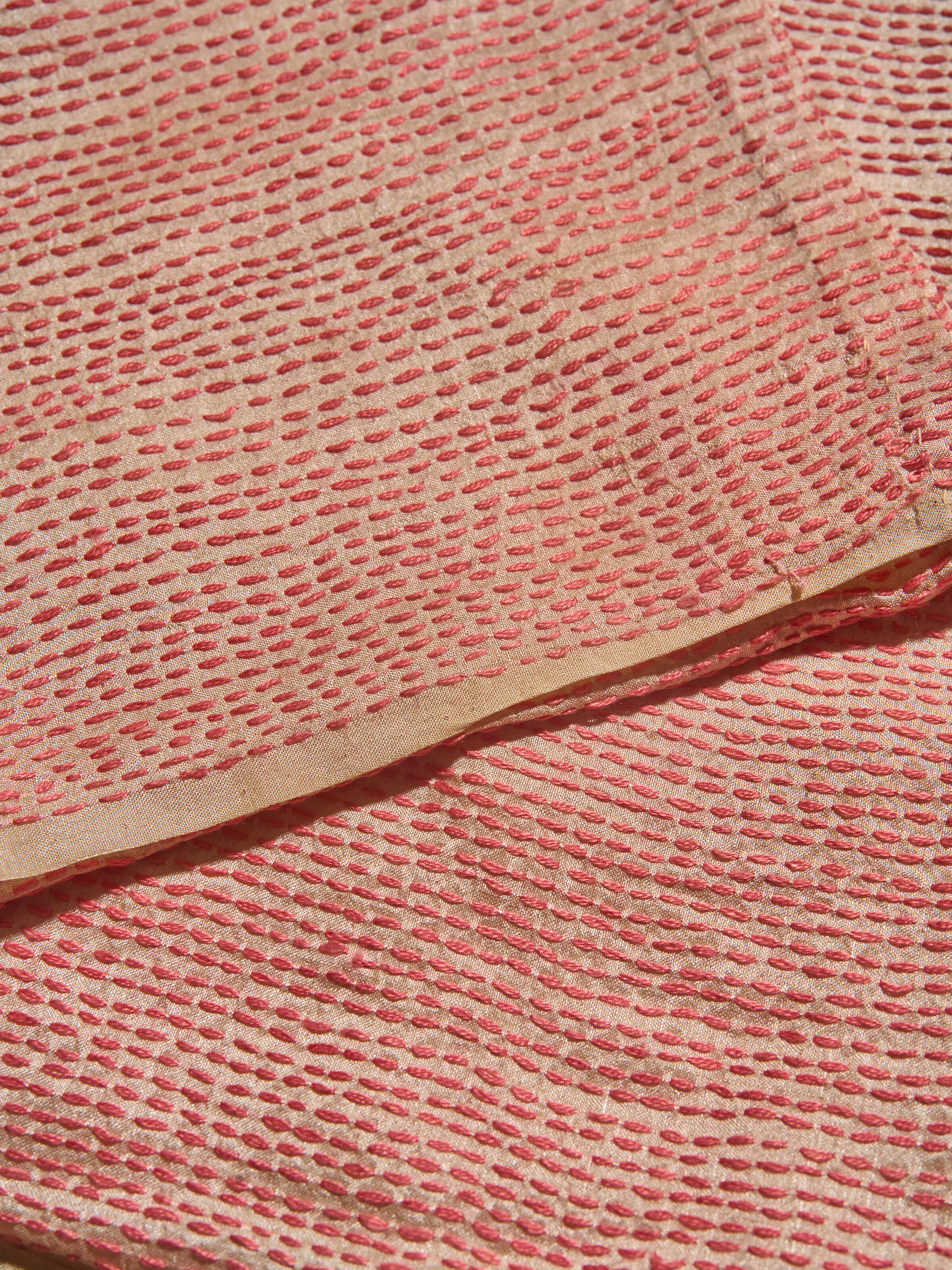 Side angle of off-white tussar silk blouse piece showcasing Sujani embroidered designs and texture.