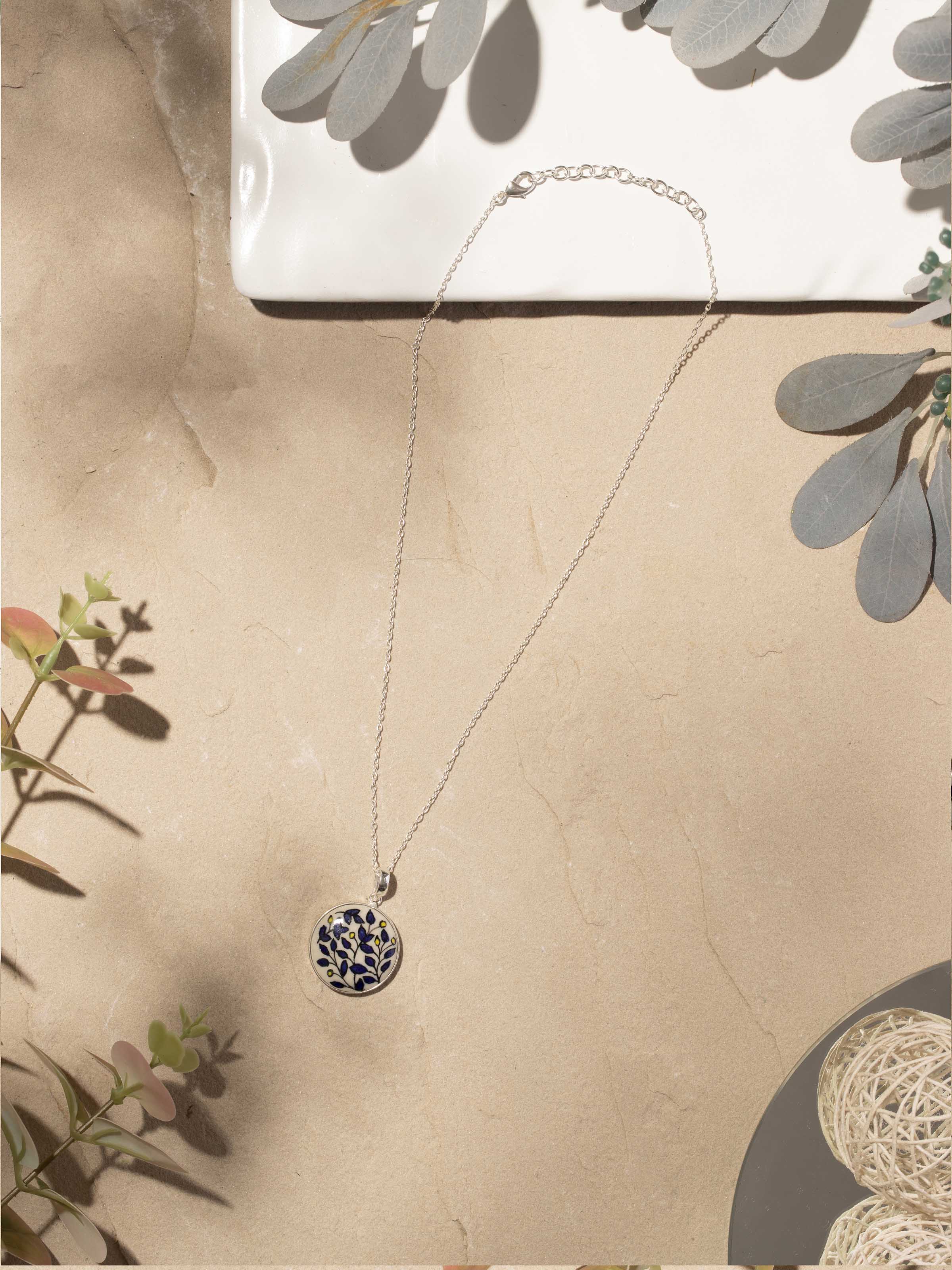 Close-up of ceramic pendant & chain with intricate patterns and colors