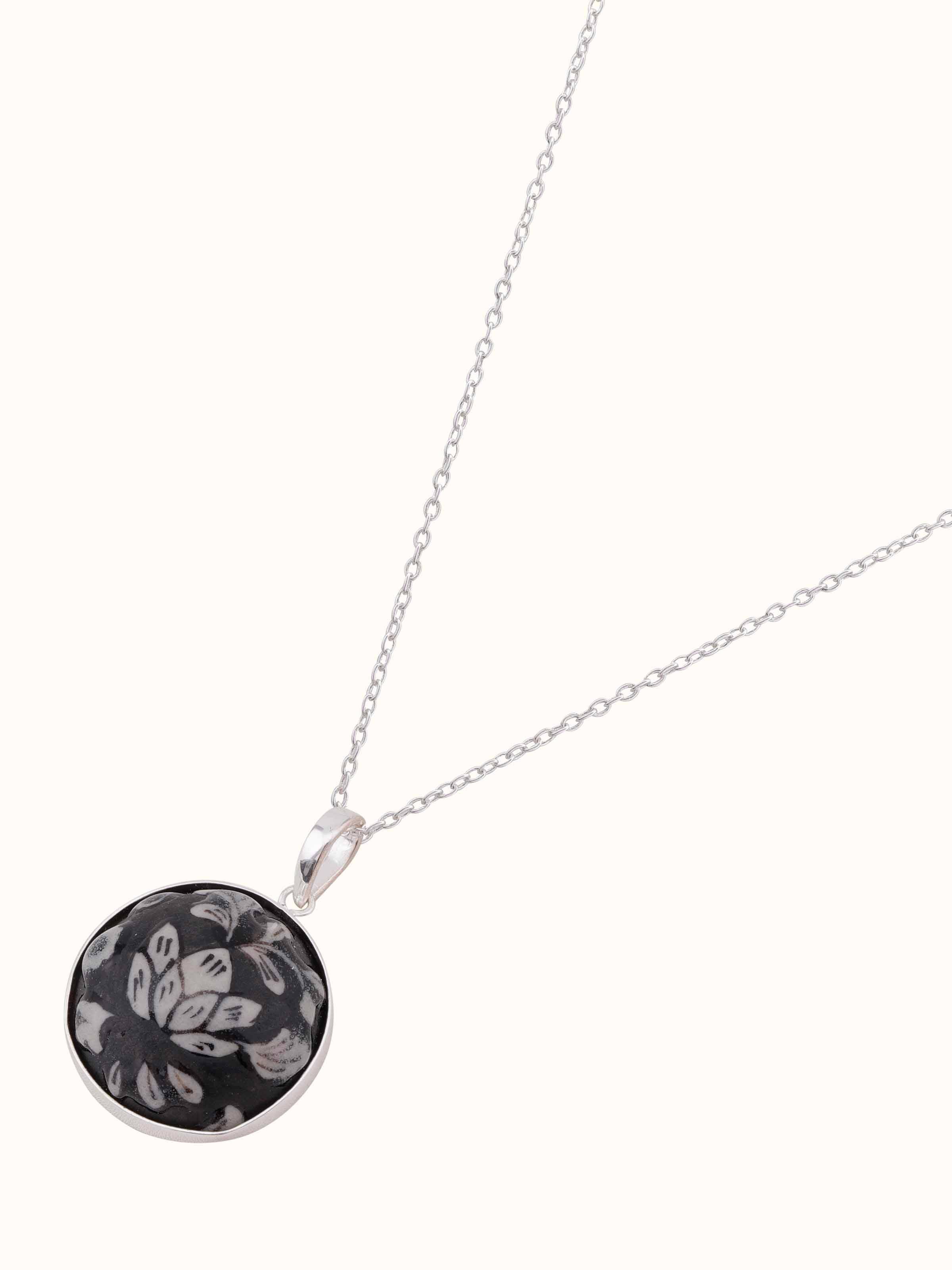 Angled view of ceramic pendant and chain highlighting its stylish and artistic design