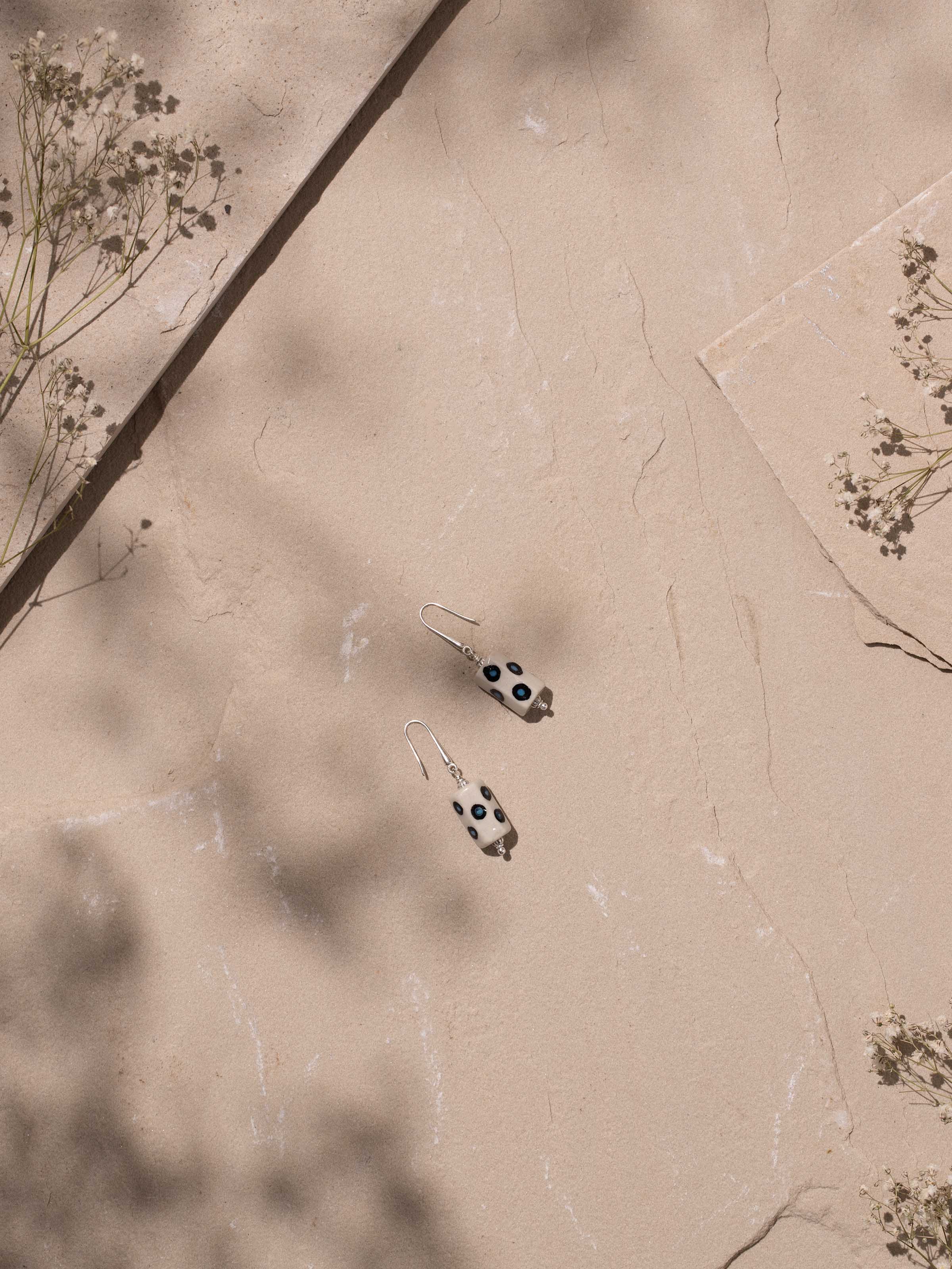 Side angle highlighting the curved shape and ceramic texture of earrings