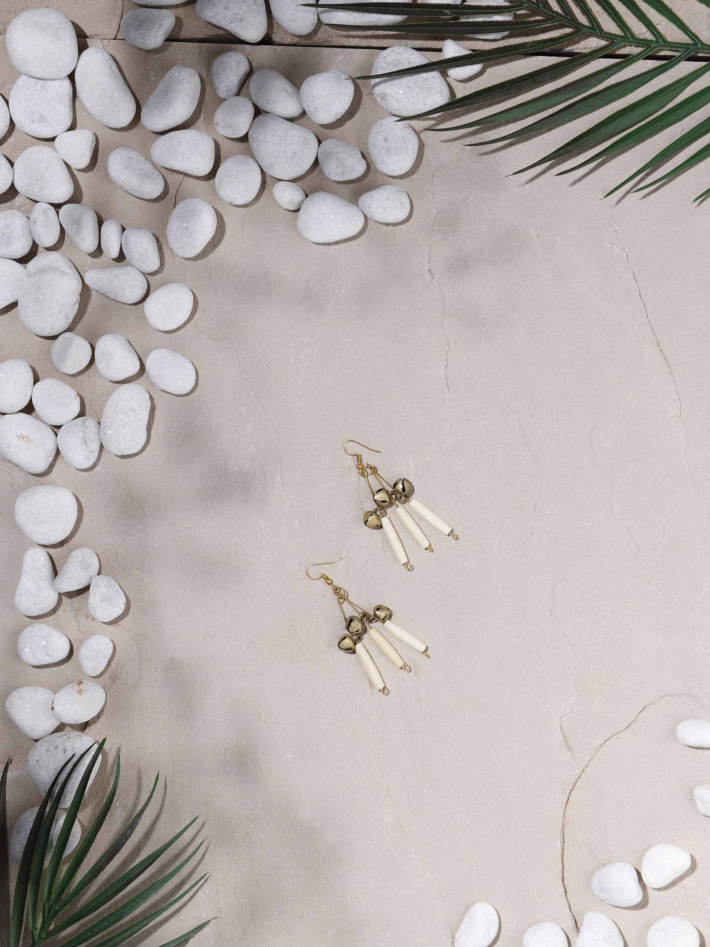 Side view of Bones & Bells drop earrings with detailed design.