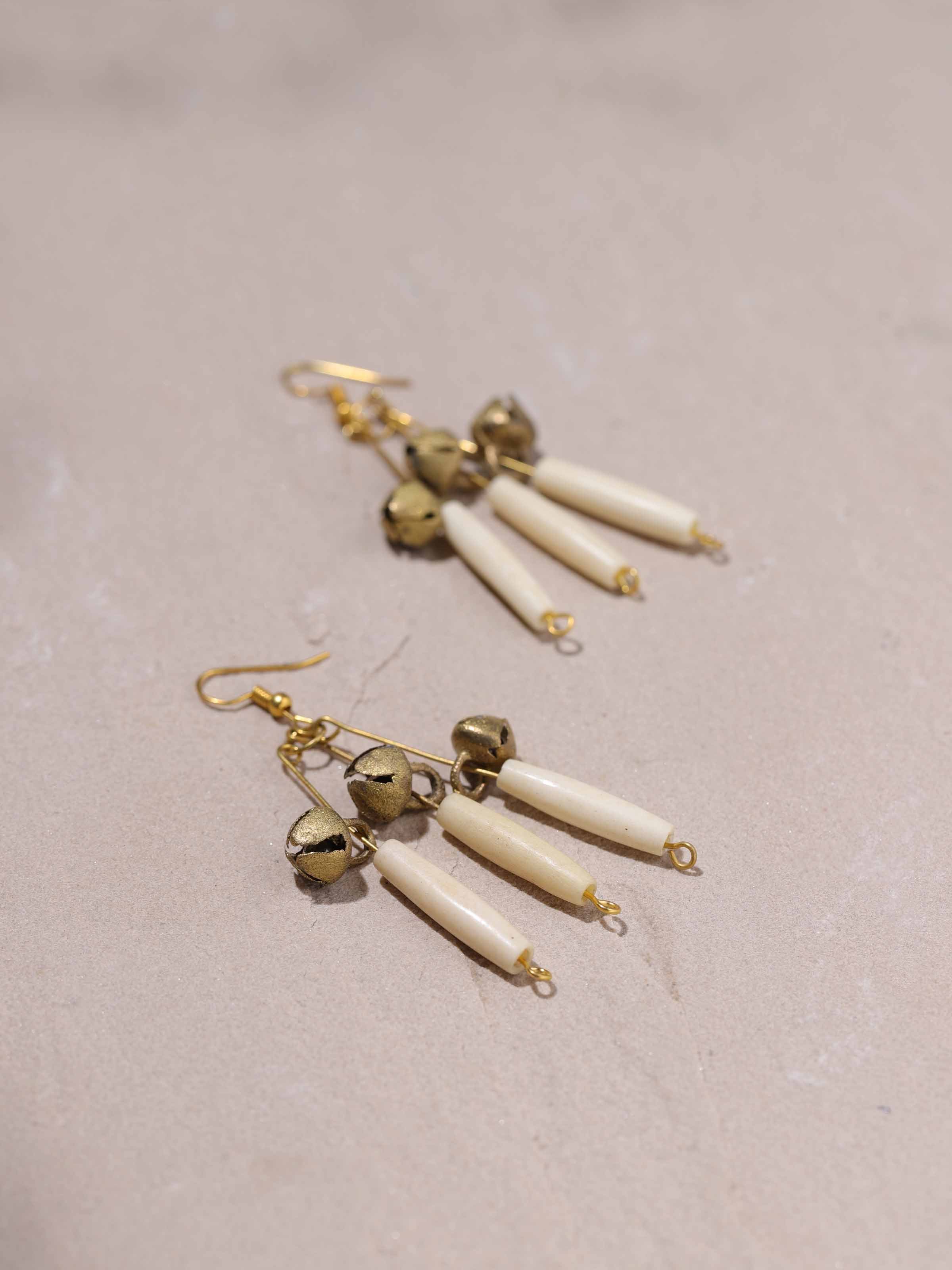 Detailed view of Bones & Bells drop earrings emphasizing intricate patterns.