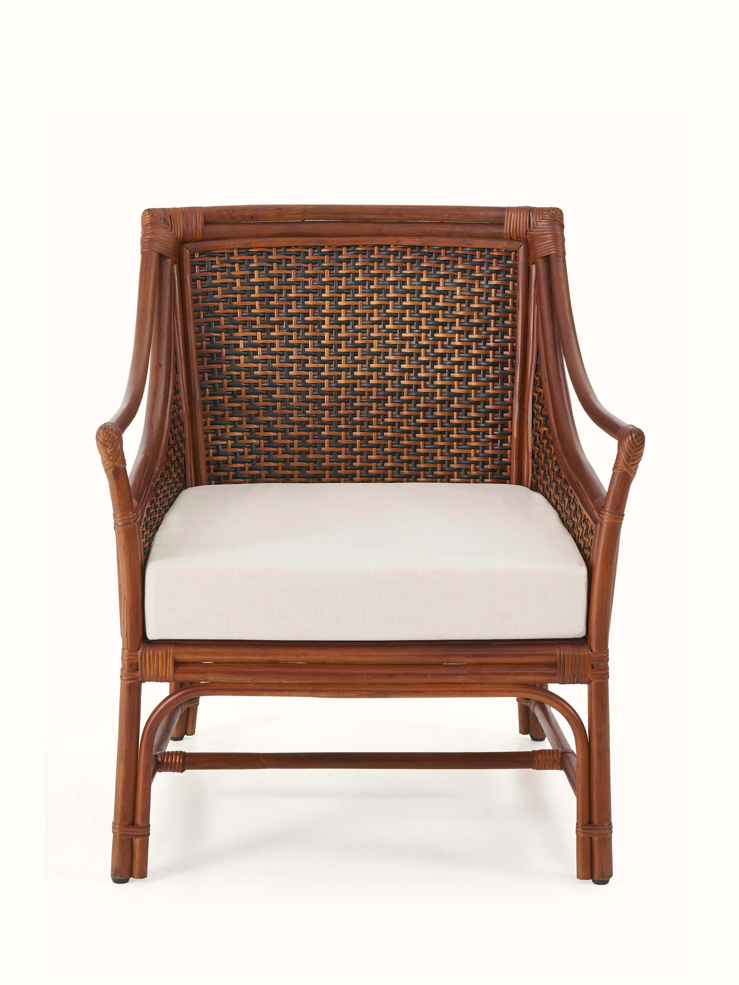 Front view of the upholstered cane and cotton armchair, showcasing its comfortable seat and elegant design.
