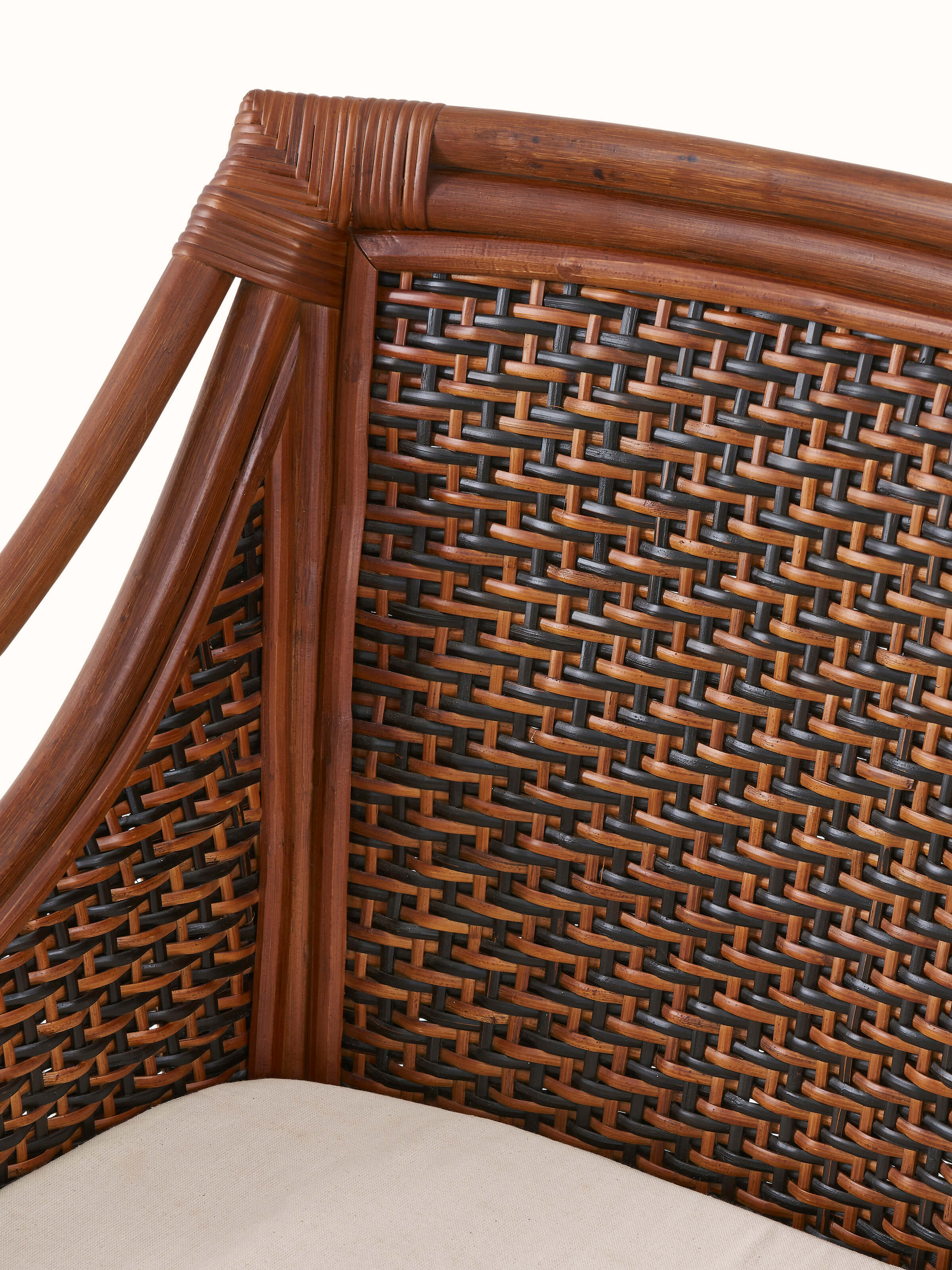 Close-up of the upholstered cane and cotton armchair, focusing on the texture of the cotton fabric and the cane work.
