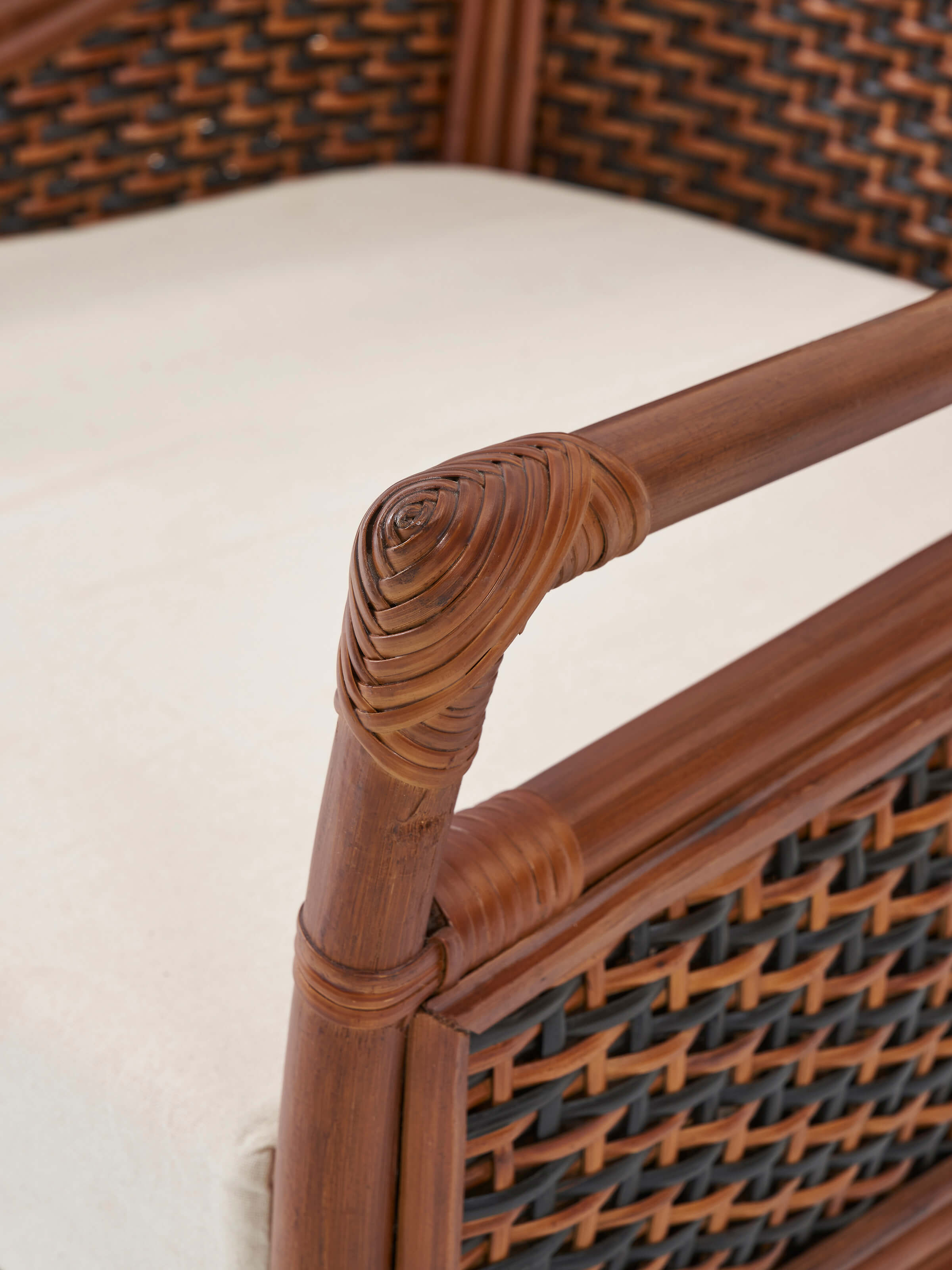 Top view of the upholstered cane and cotton armchair, showcasing the cushion and cane back.