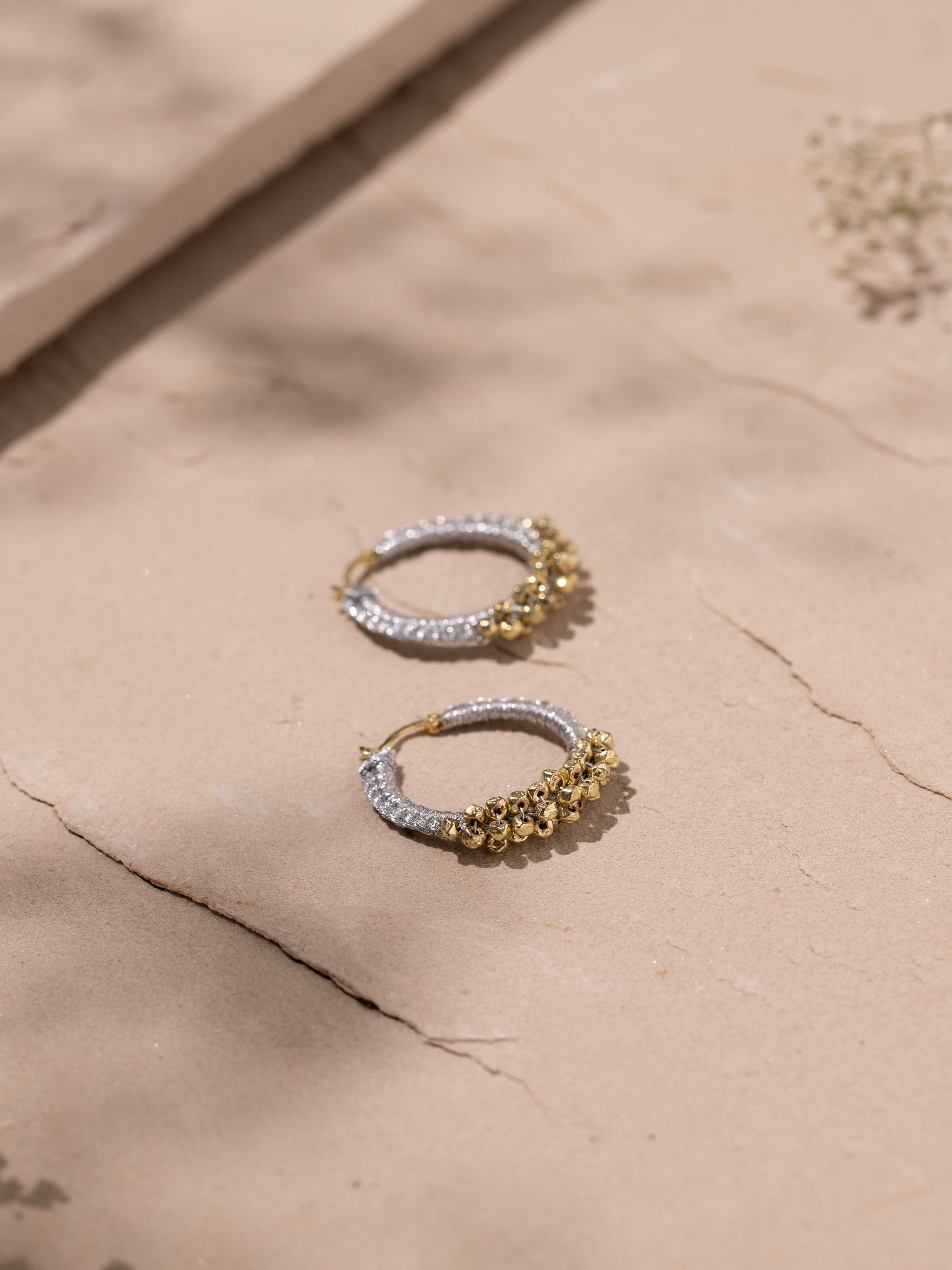 Detailed shot of Zari Patwa hoop earrings focusing on ornate zari work.