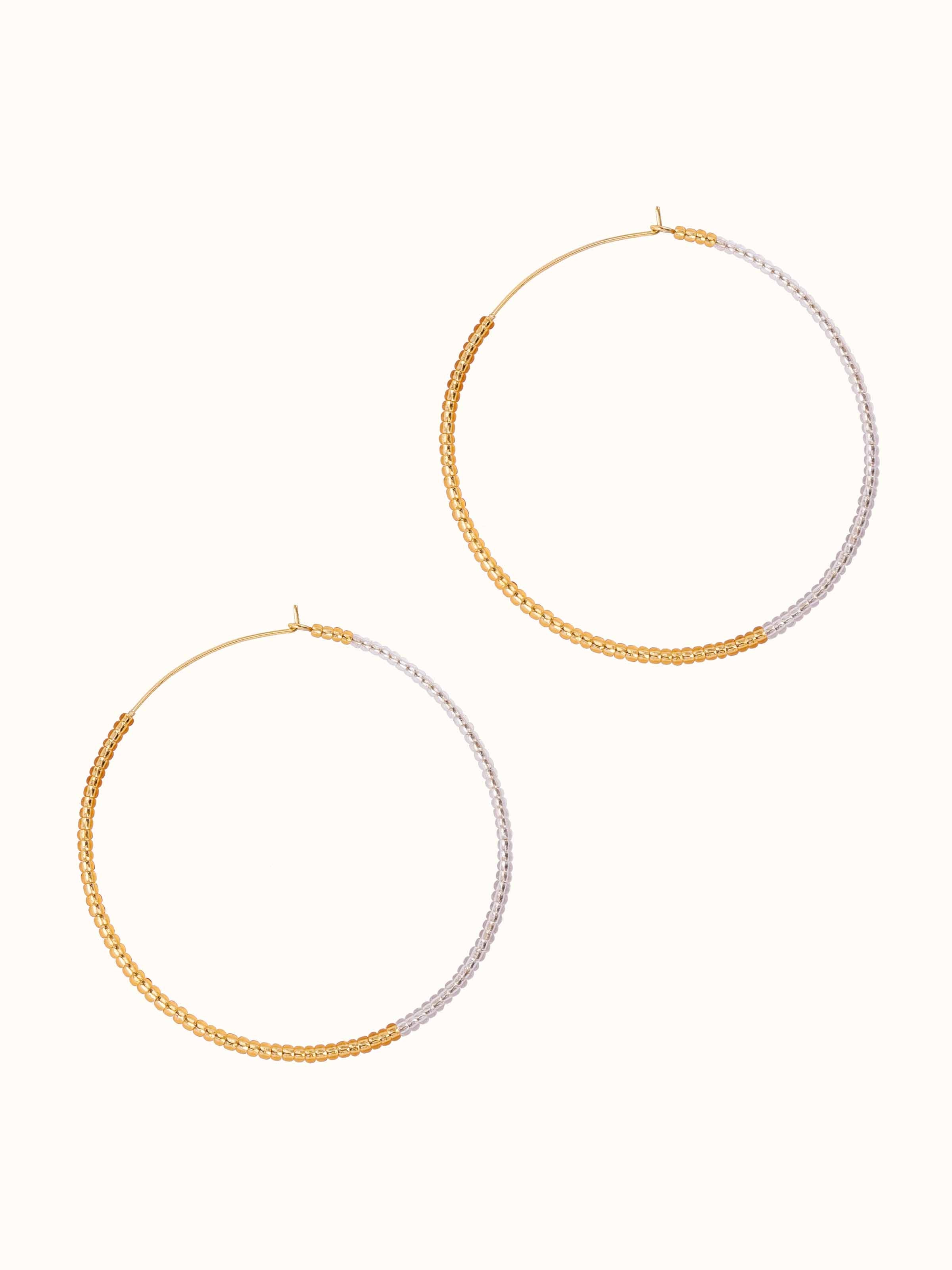 Angled view of handcrafted hoop earrings with detailed design elements