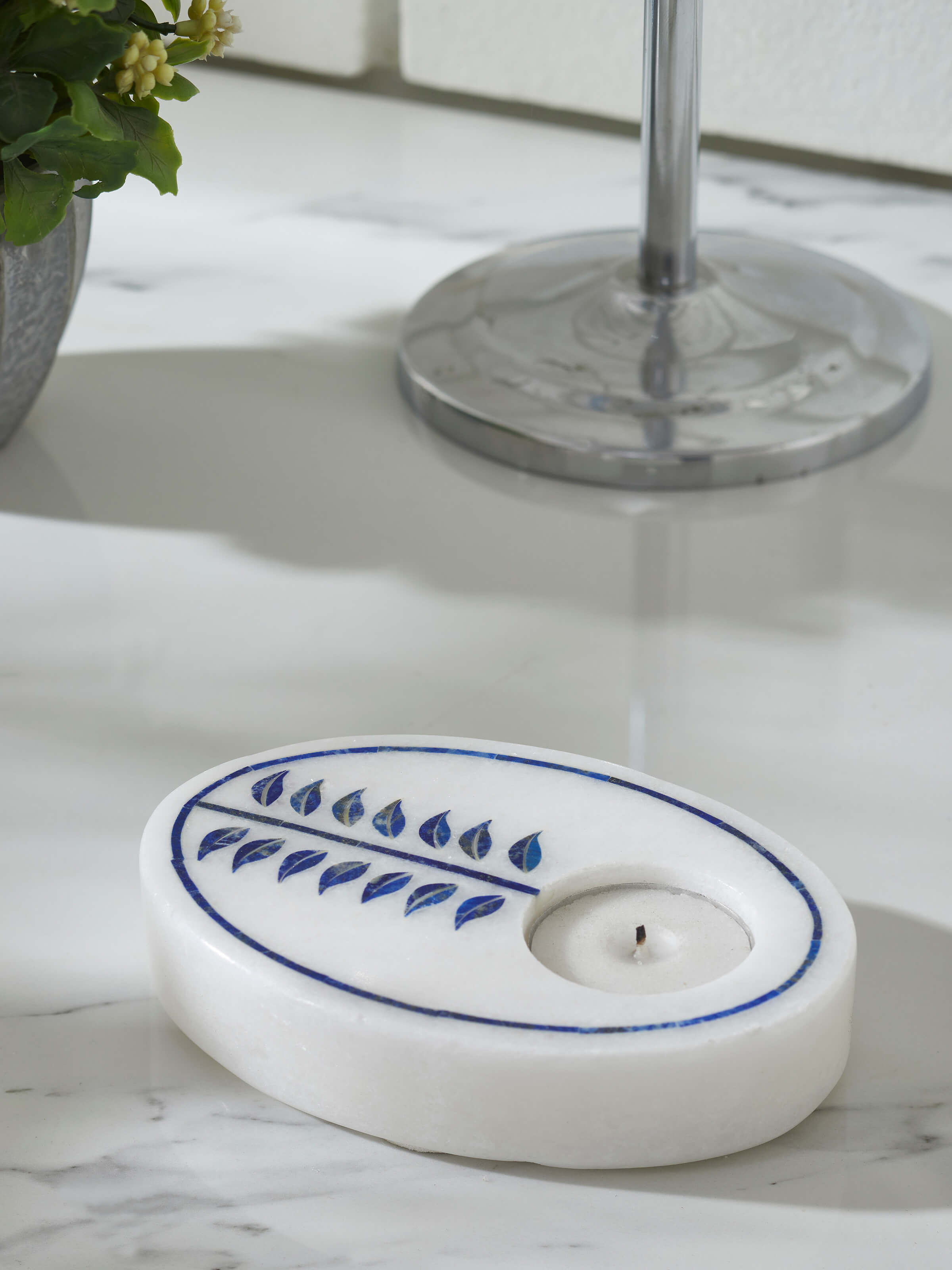 Front view of a white Pacchikari marble tea light holder, highlighting its intricate carvings and delicate appearance.