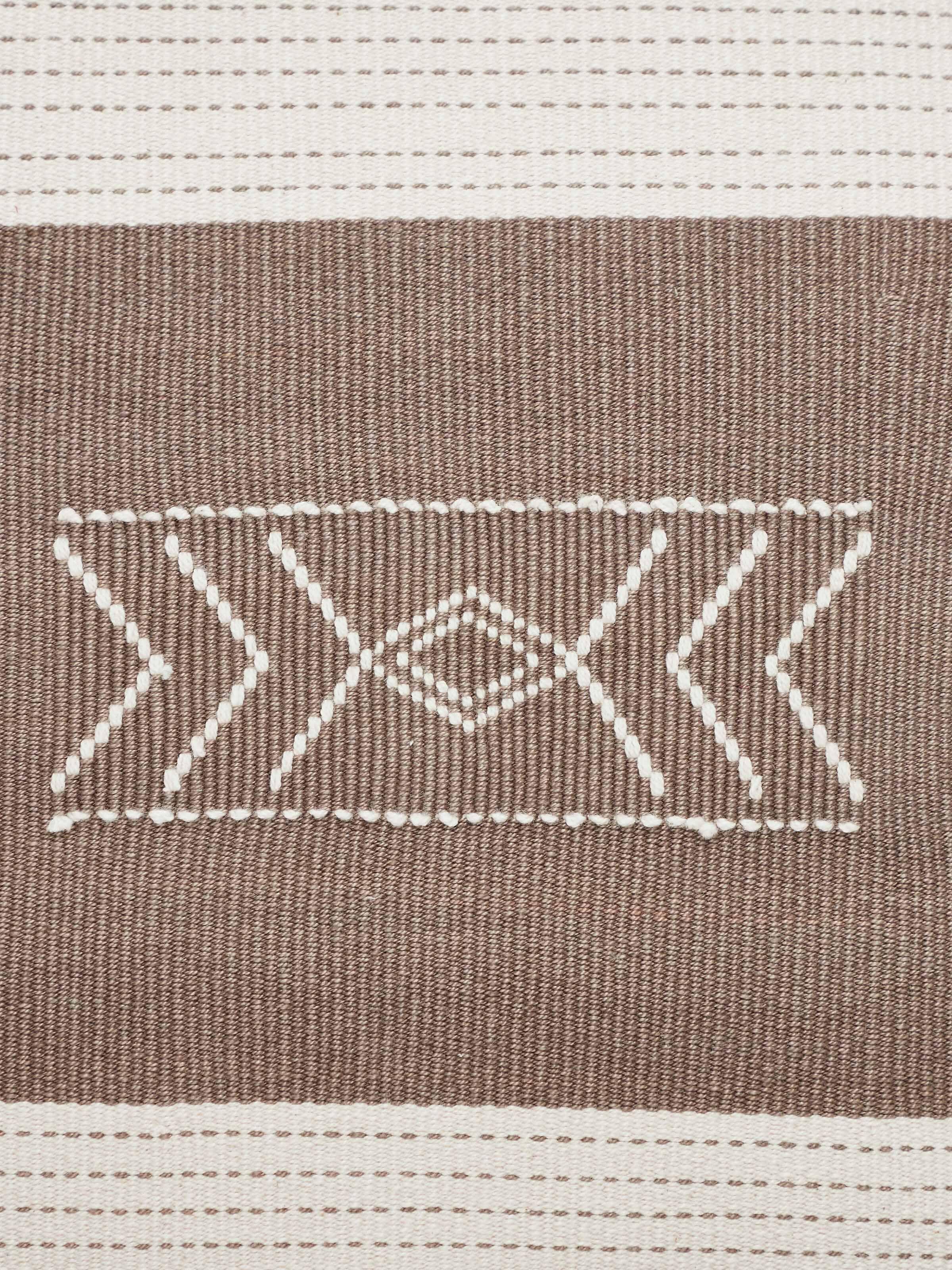 Side view of Ridhama khakhi barnava cotton Naga handloom cushion cover emphasizing its handloom texture