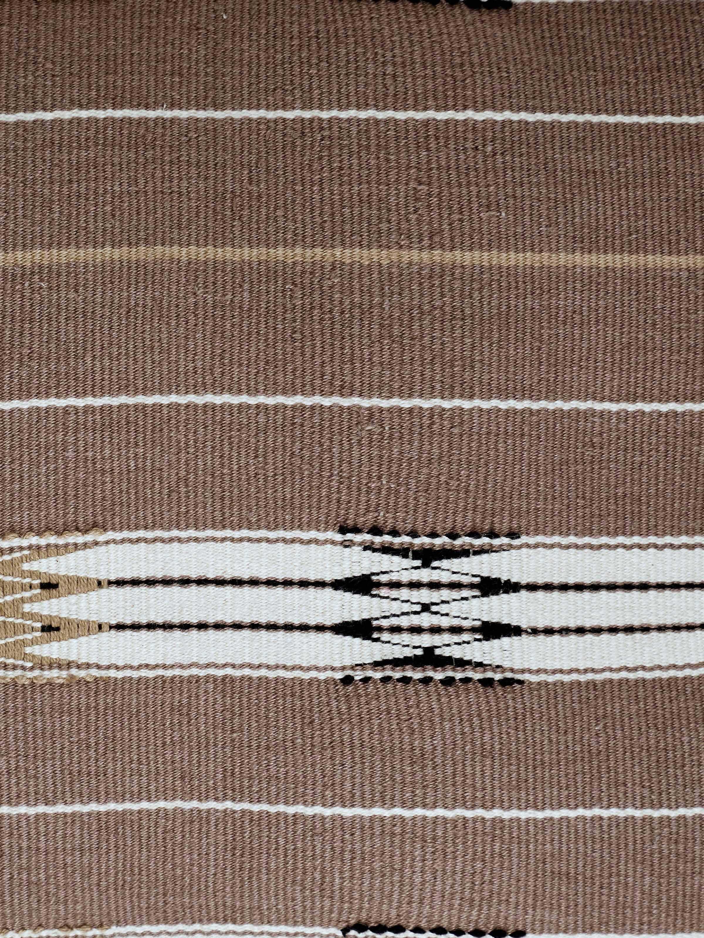 Folded view of Ridhama khakhi jani cotton Naga handloom cushion cover emphasizing its texture and color.