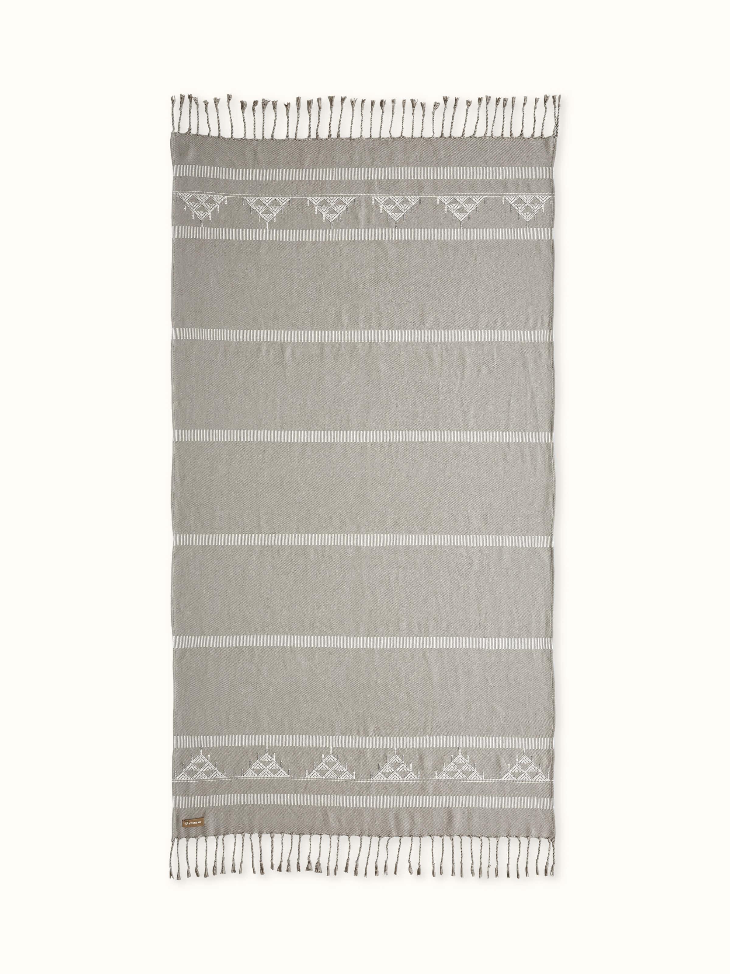 Front view of beige striped cotton Pattu throw with handwoven detailing, ideal for layering.
