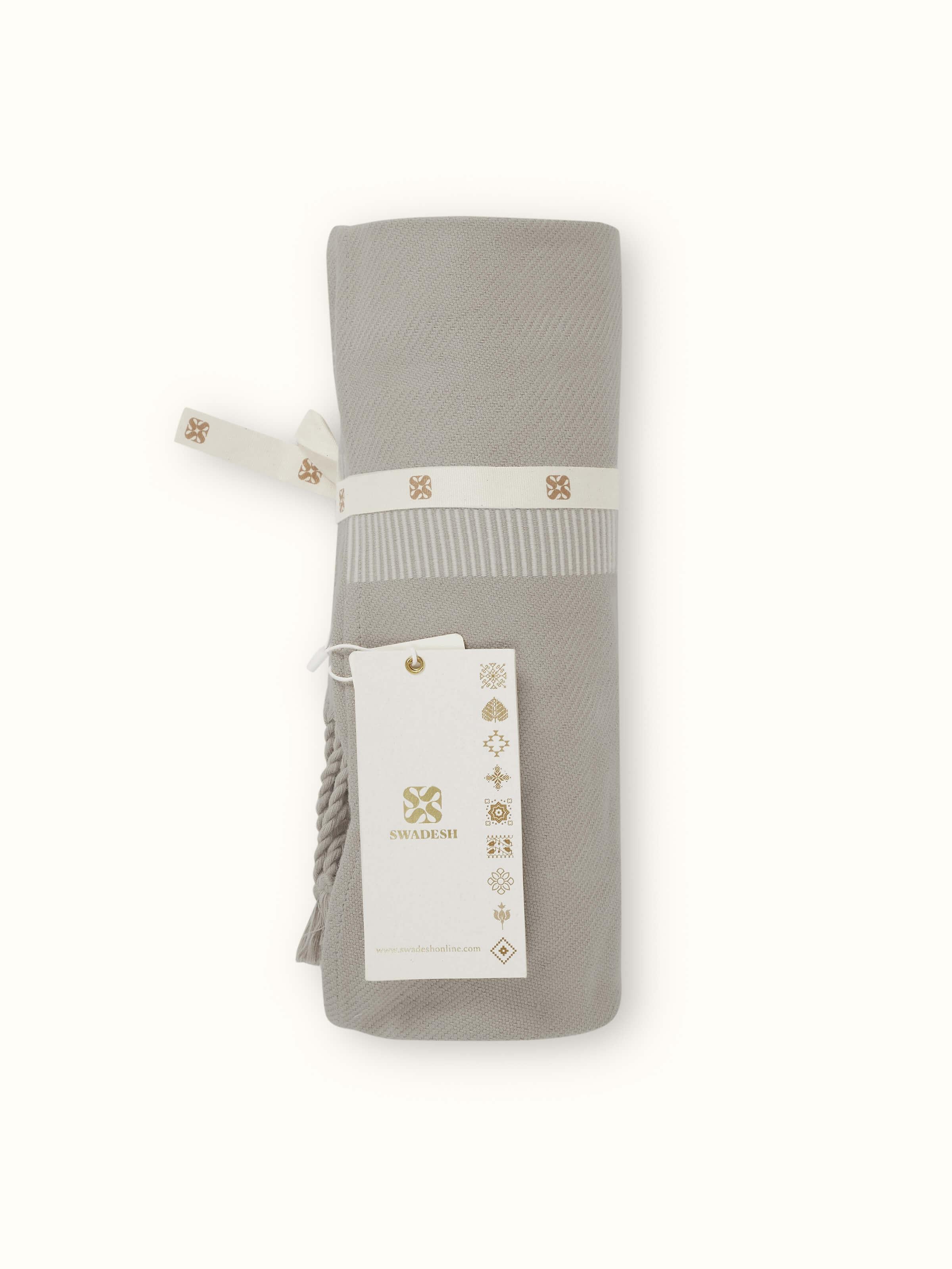 Close-up showing detailed handwoven cotton texture and neat stripe design of the throw.